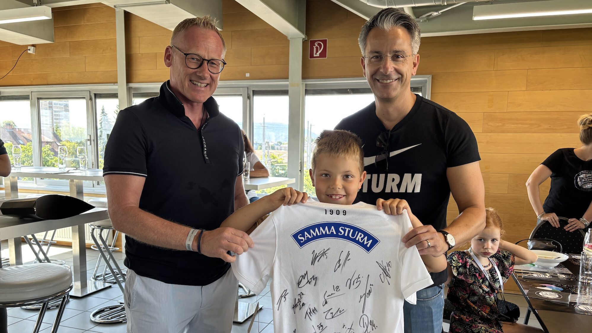 Zwei Männer ein Kind ein Trikot