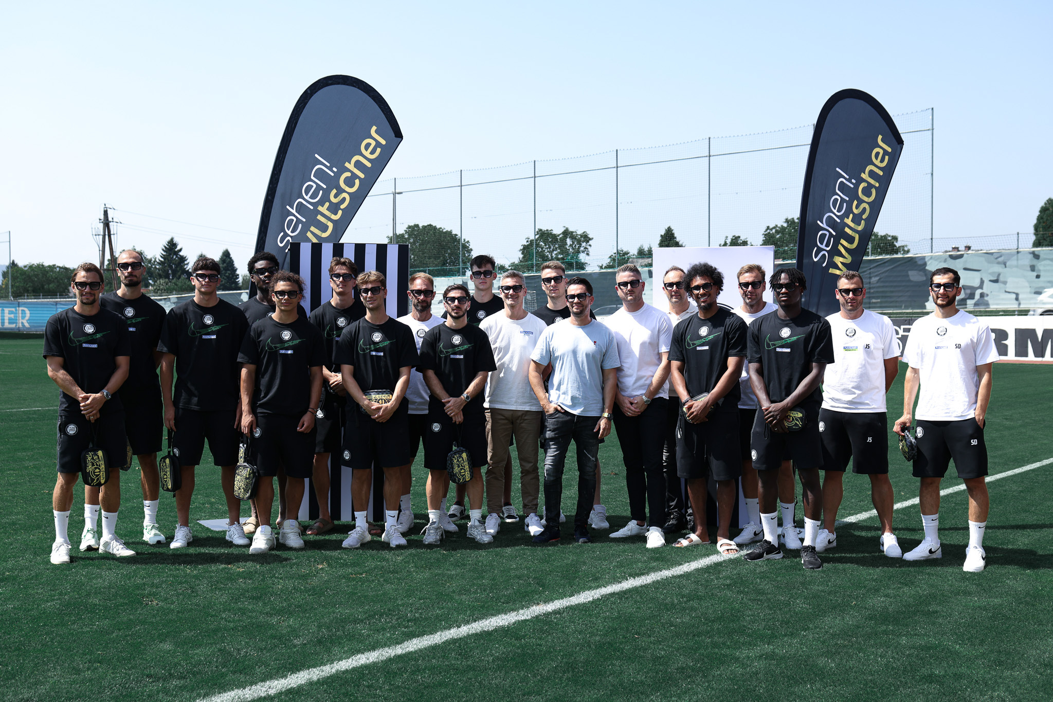 Fußballmannschaft am Feld mit Sonnenbrillen