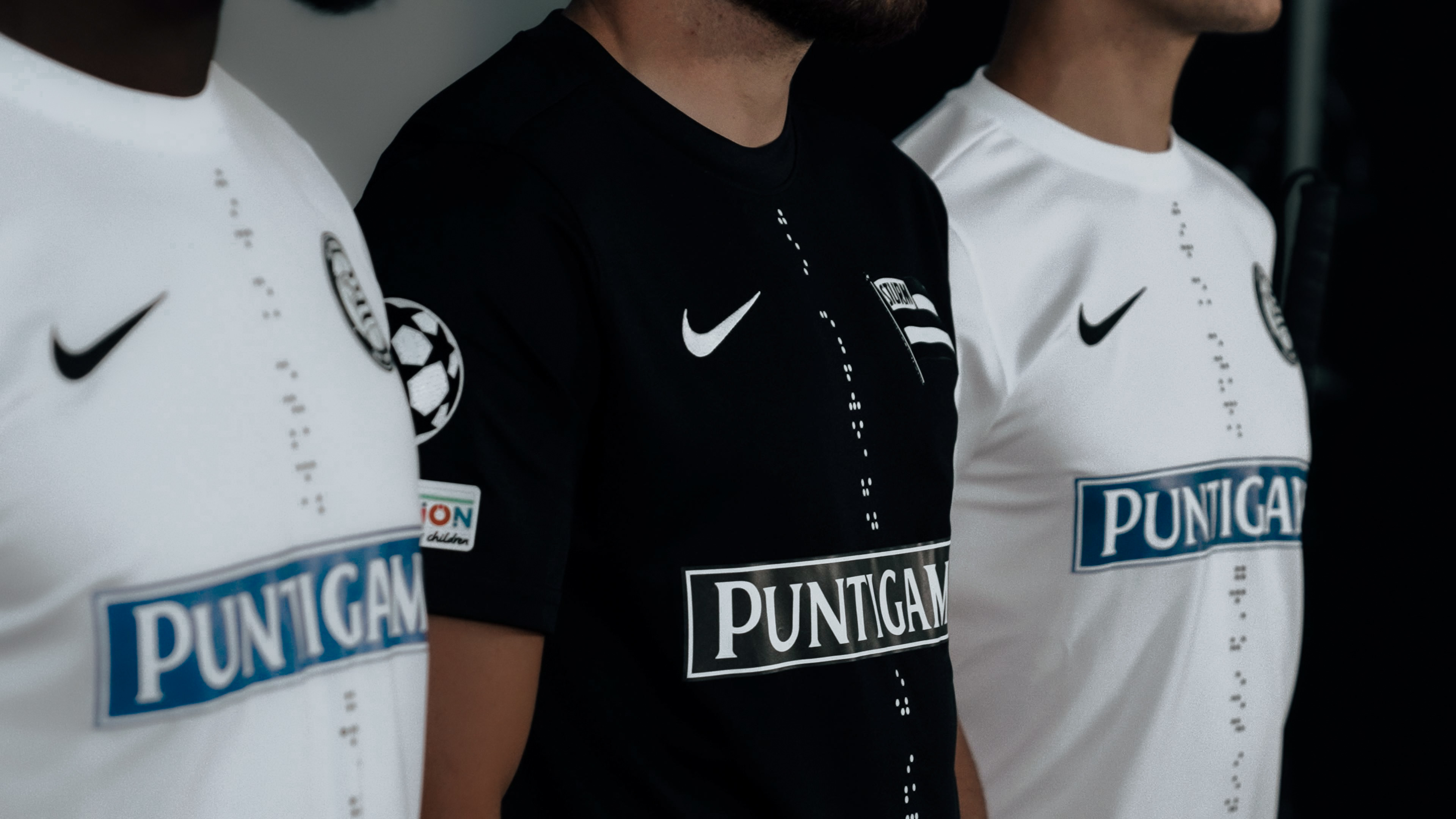 Zwei weiße, ein schwarzes Trikot