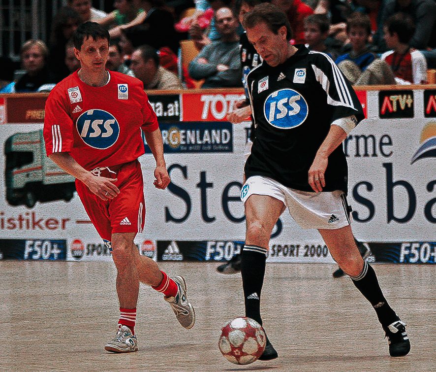 Zwei Männer spielen Fußball.
