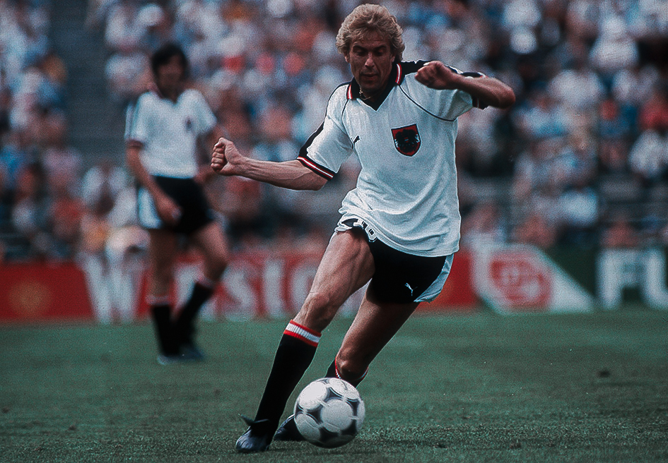 Ein Mann im Fußballdress mit Ball.