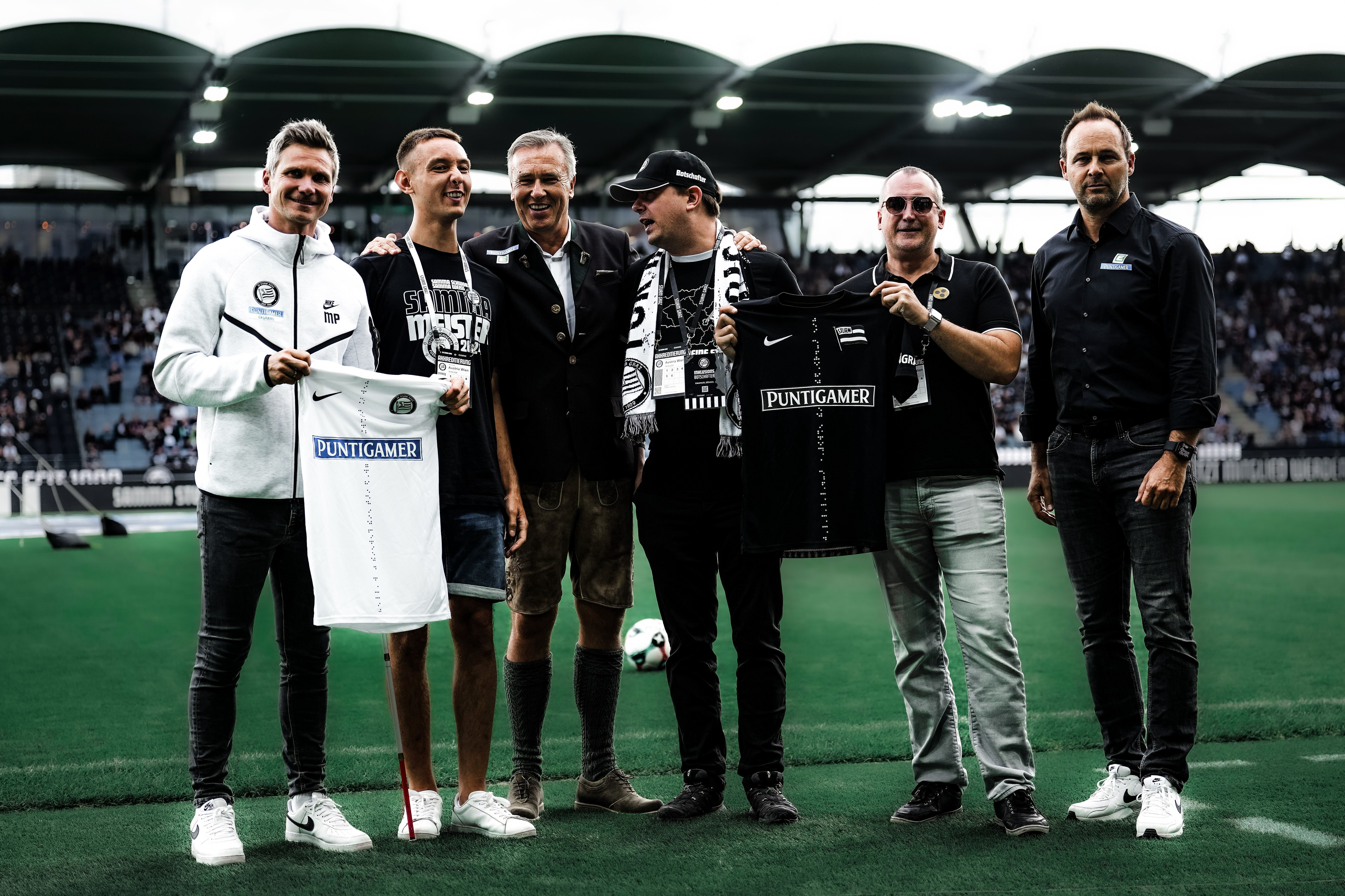 Gruppenfoto der Verantwortlichen des SK Sturm mit Sturm-Fans des Blinden- und Sehbehindertenverbandes Steiermark.