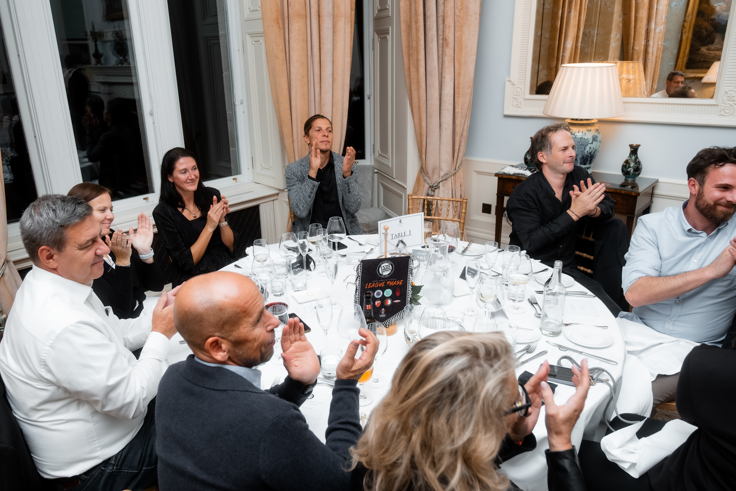 Menschen an einem runden Tisch, die applaudieren