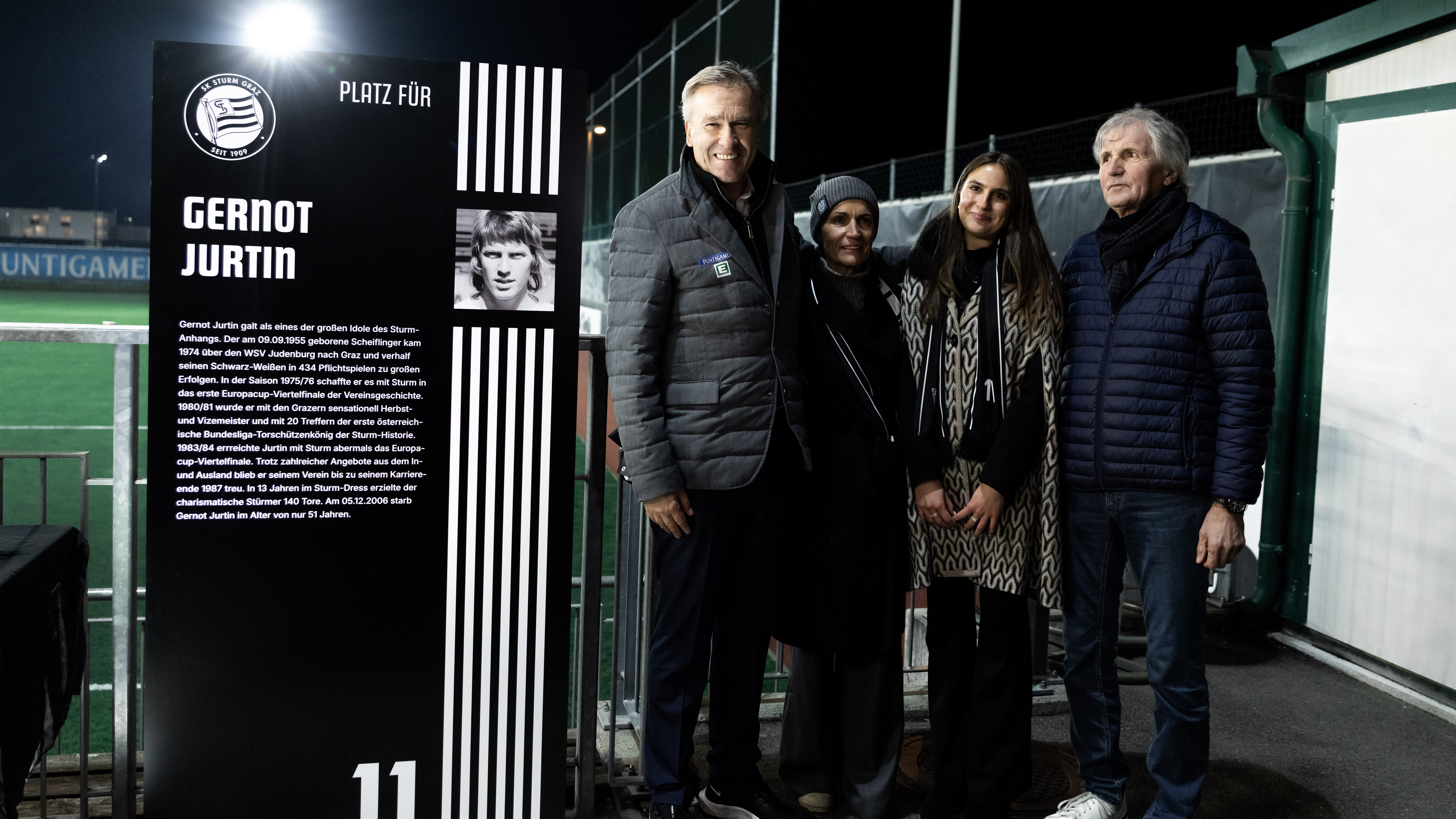 Zwei Männer und zwei Frauen stehen neben einer Stele