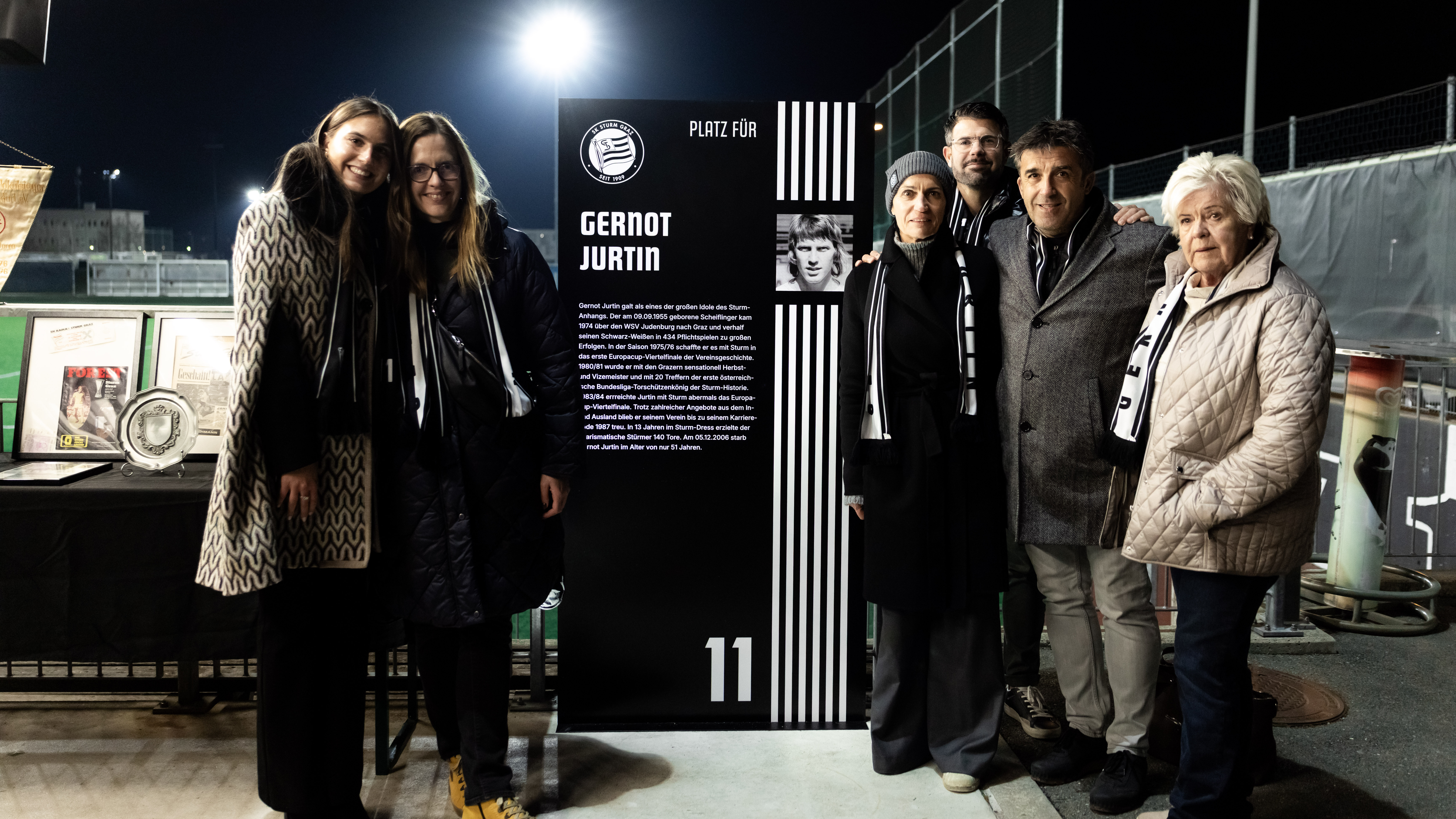 Männer und Frauen vor einer Stele