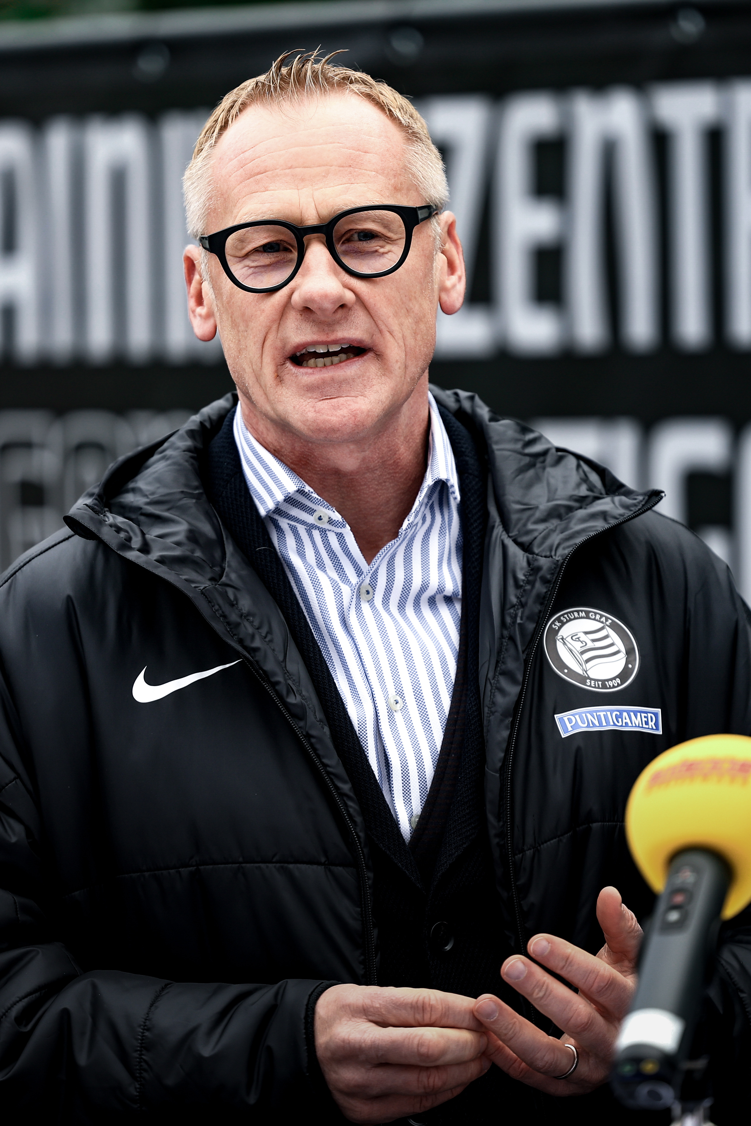 Ein MAnn spricht in ein Mikrofon