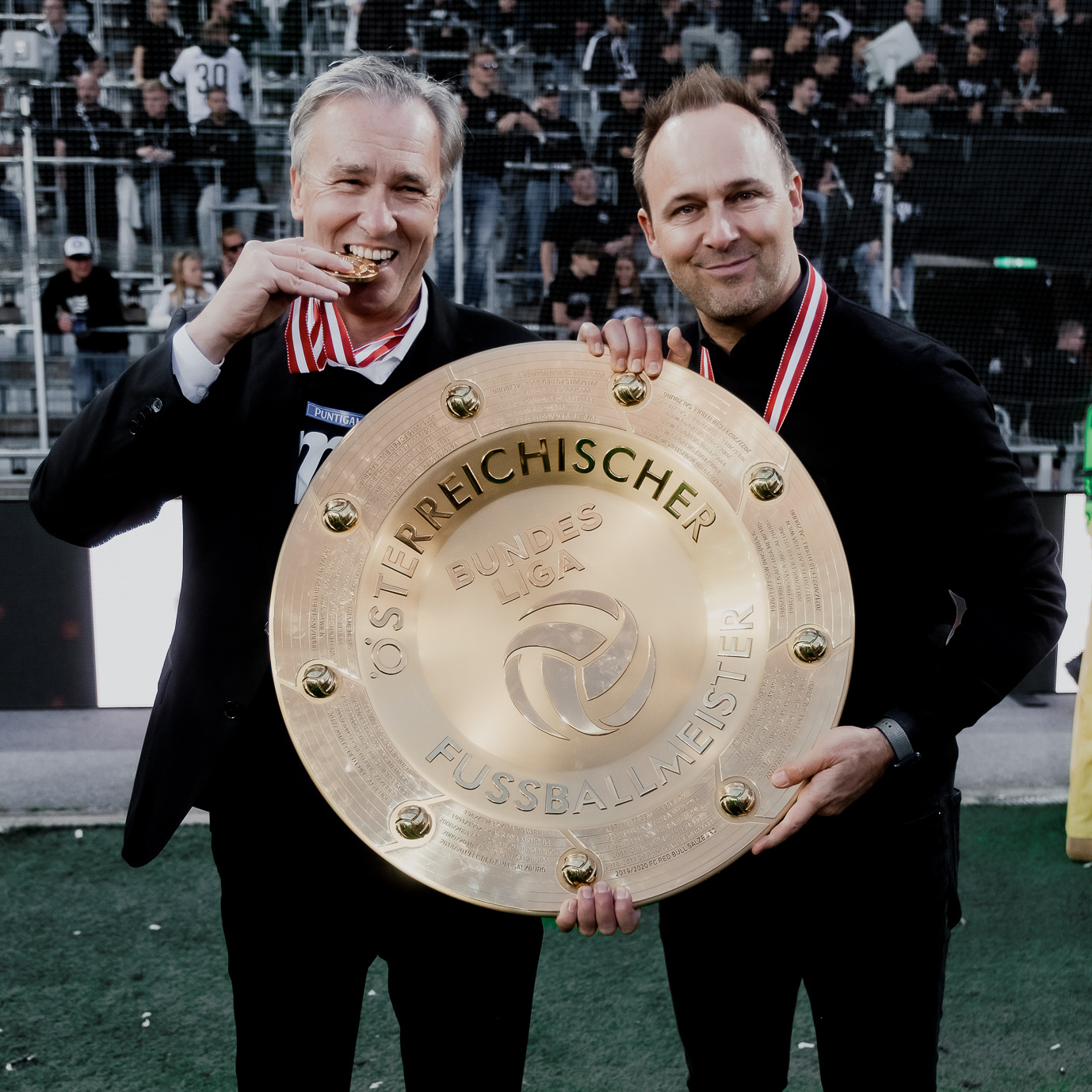 Zwei Männer mit einer Trophäe.