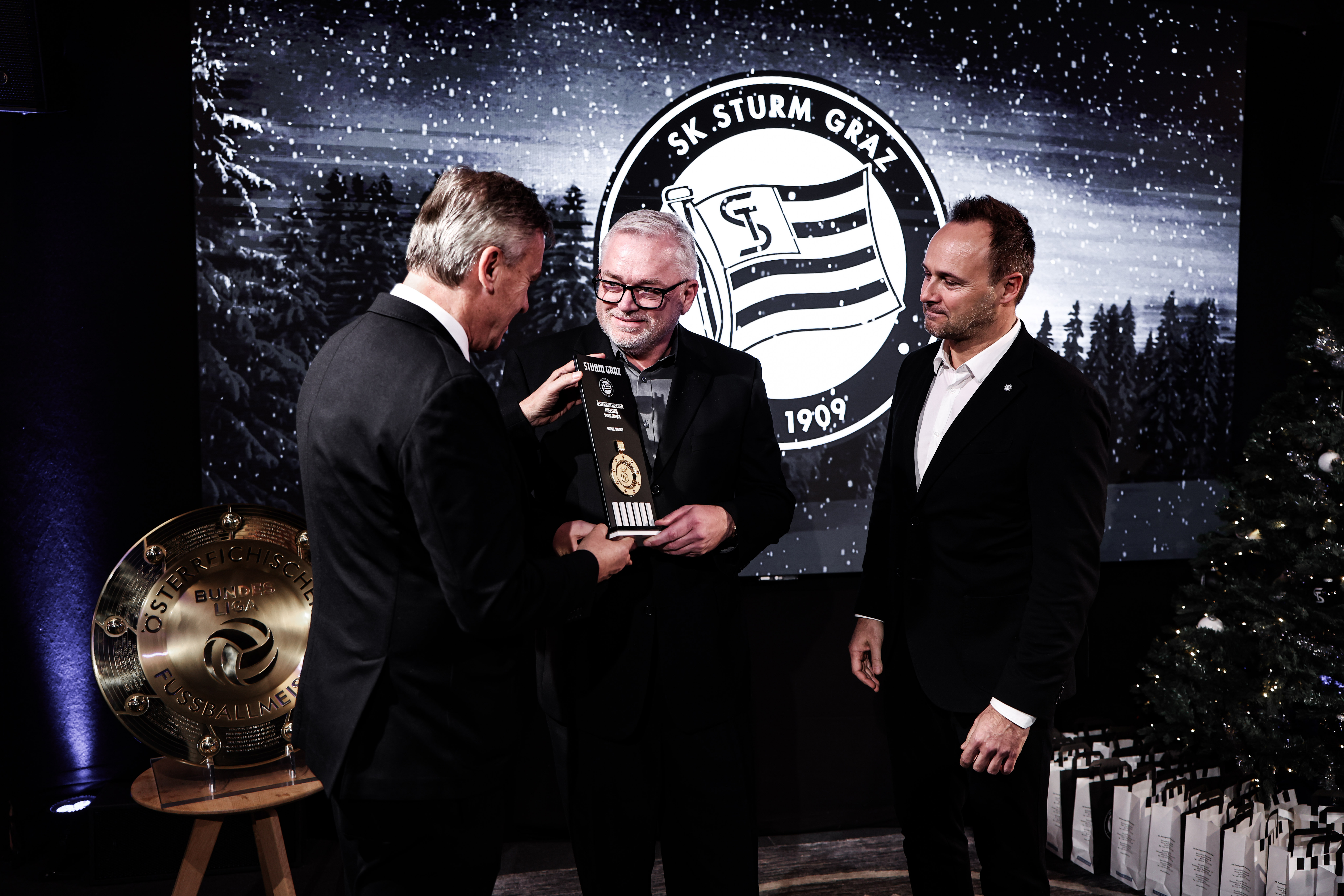 Ein Mann bekommt einen Pokal überreicht