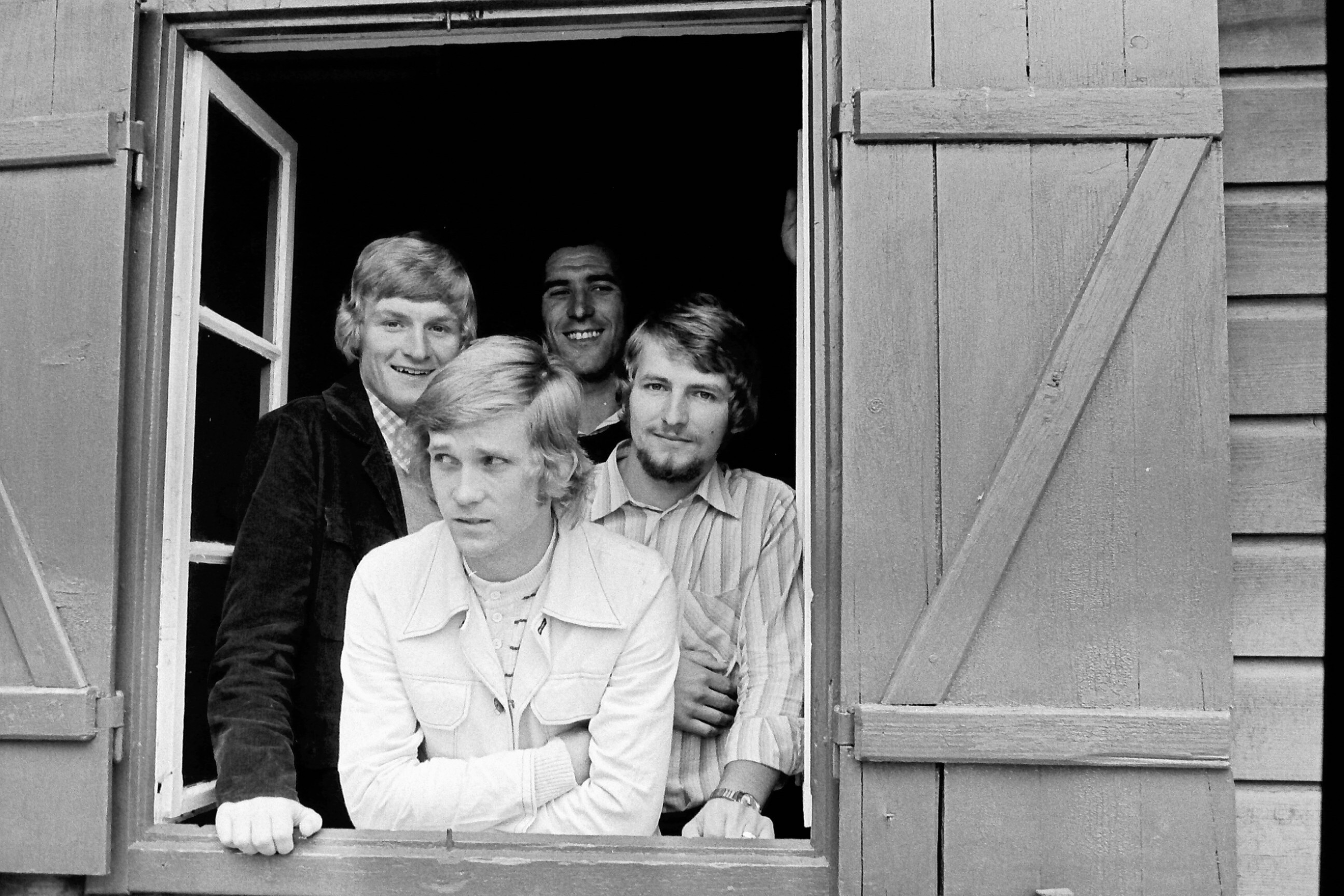 Vier Männer schauen aus einem Fenster