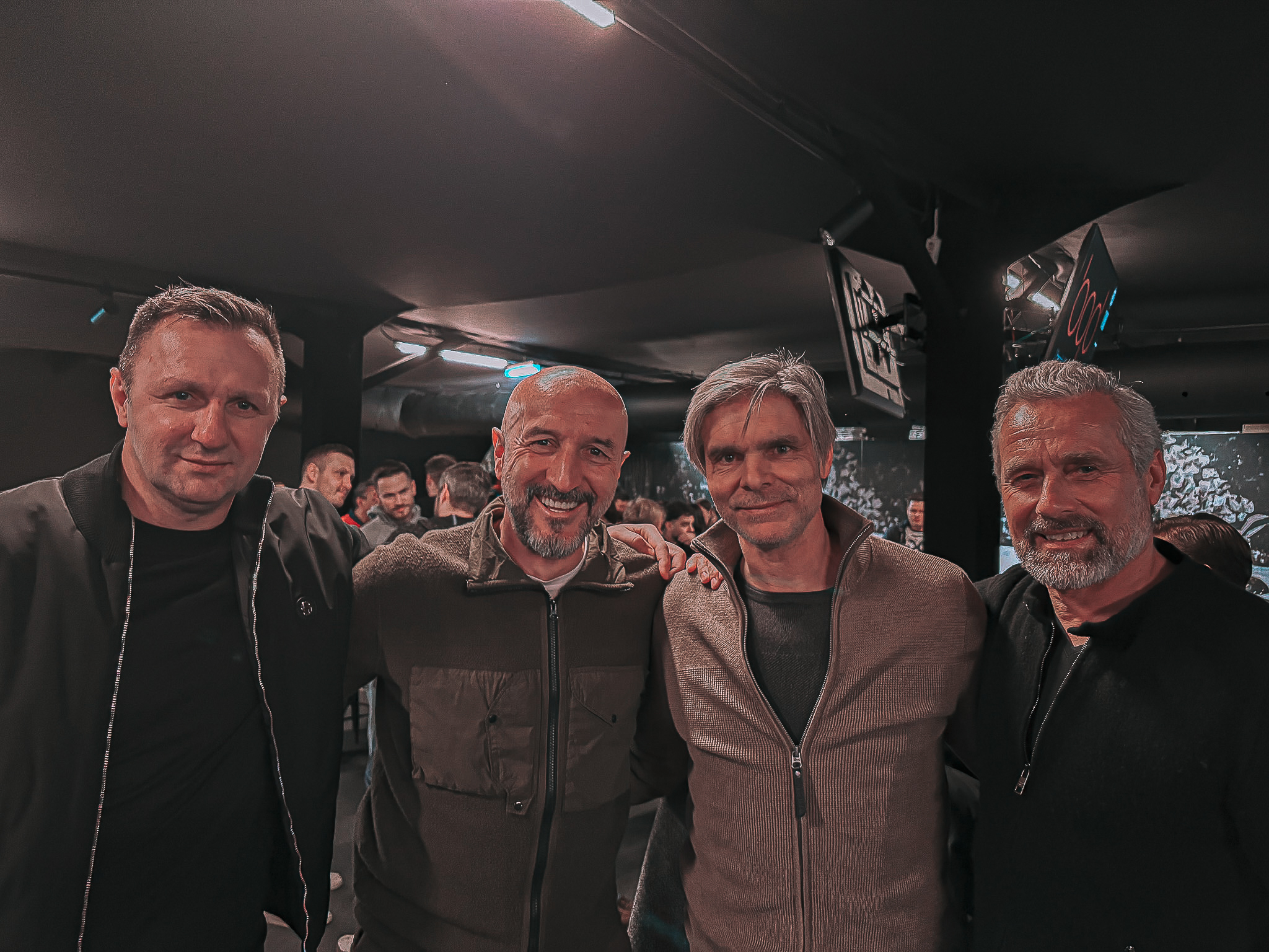 Vier Männer lachen in die Kamera.