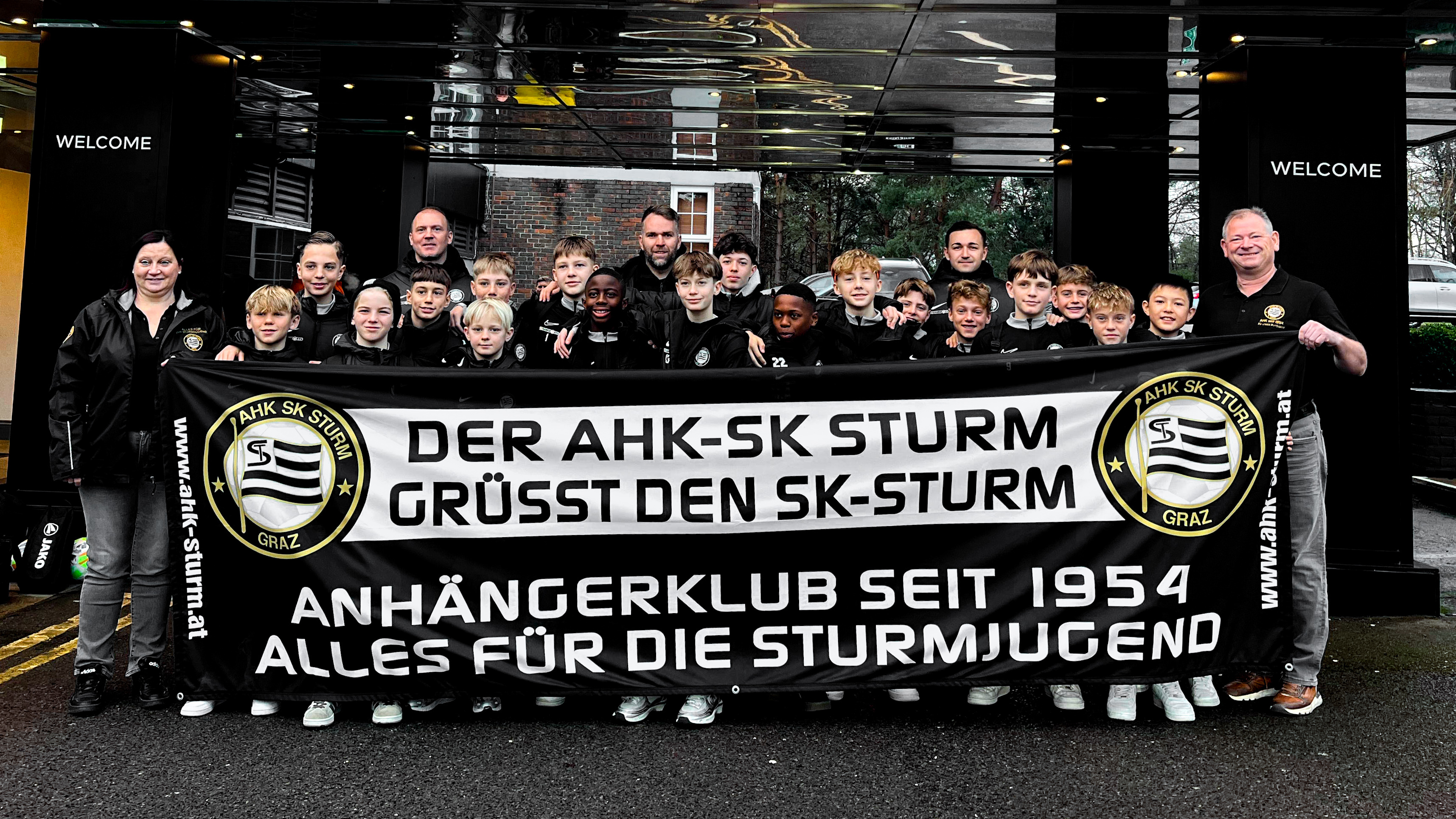 Eine Jugend-Fußball-Mannschaft vor einem Plakat.