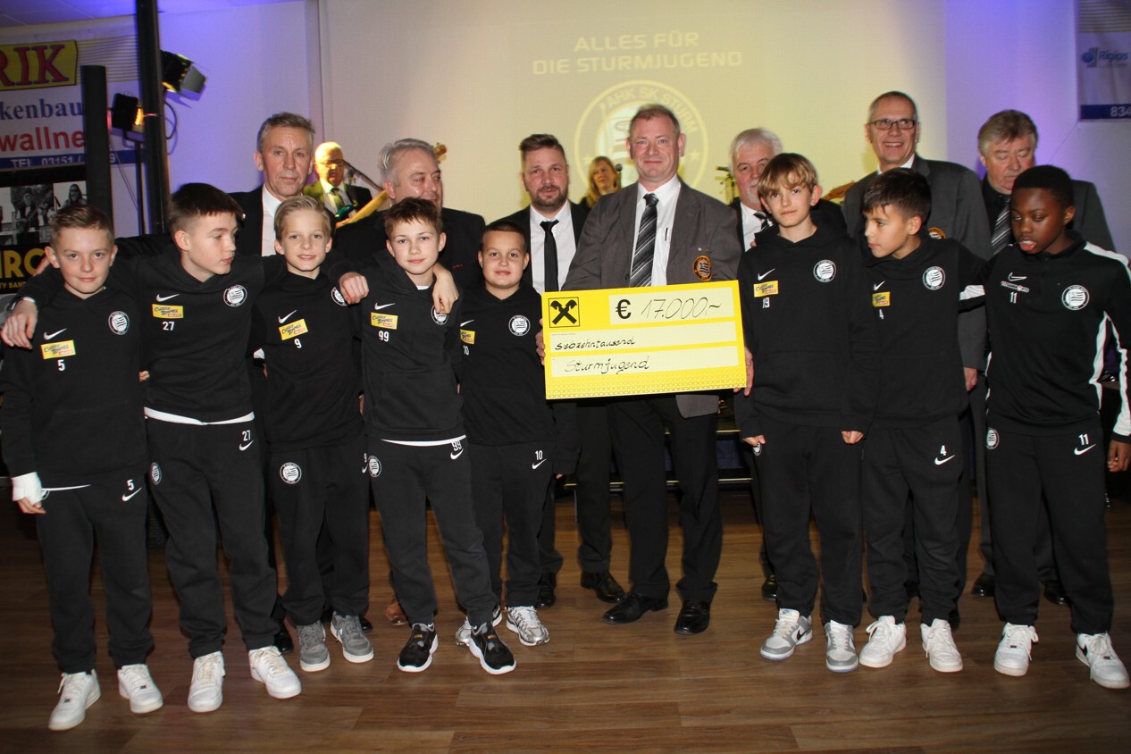 Eine Gruppe Jugendliche und Erwachsene mit einem Scheck.