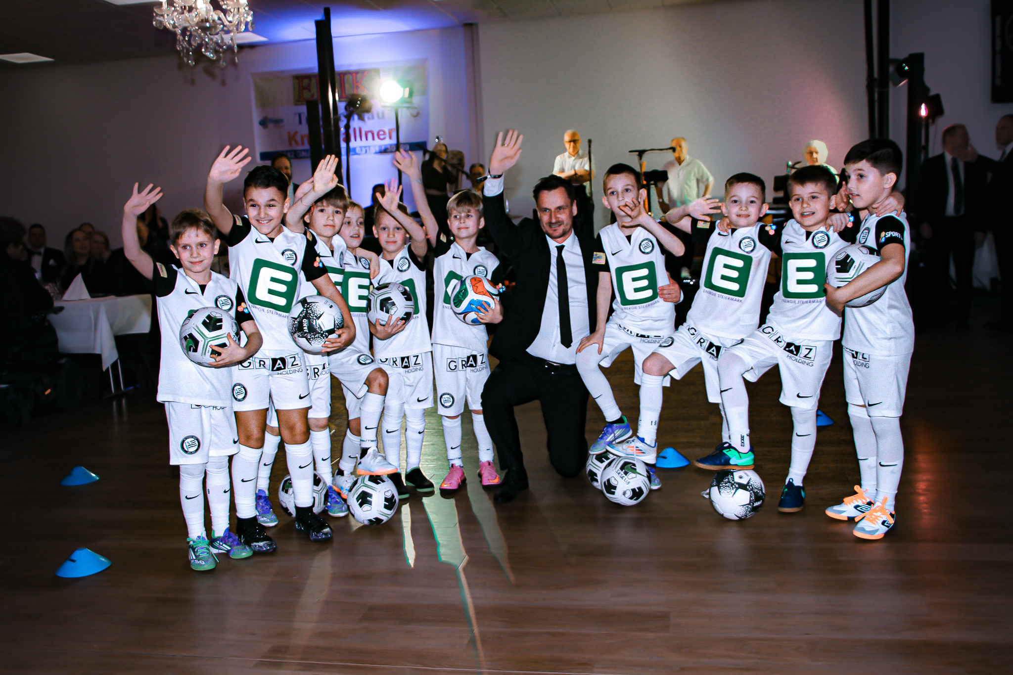 Viele Kinder in Dressen und ein Mann jubeln