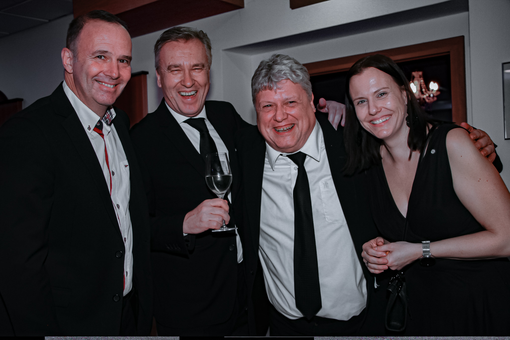 Drei Männer und eine Frau stoßen an.