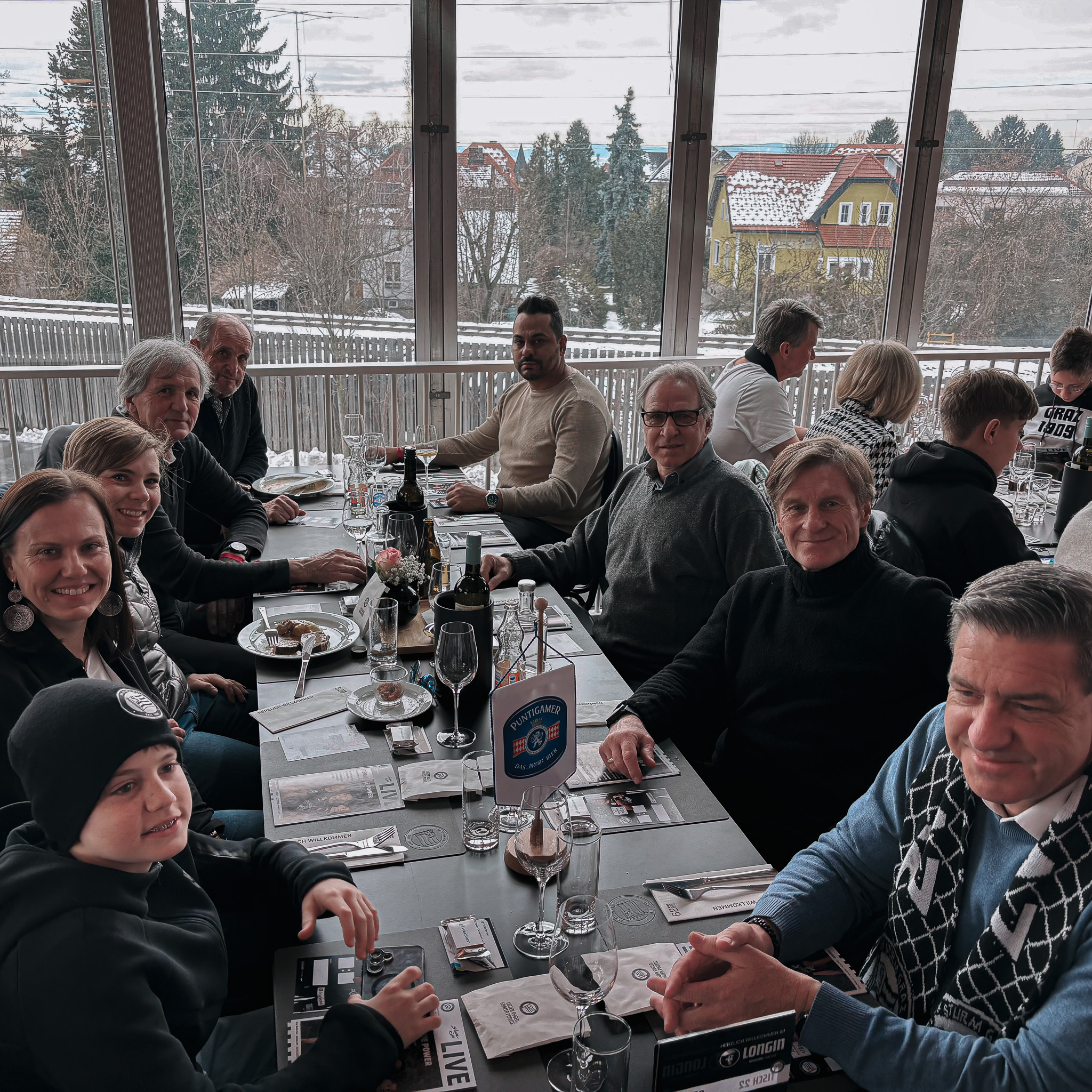 Neun Menschen sitzen an einem Tisch.