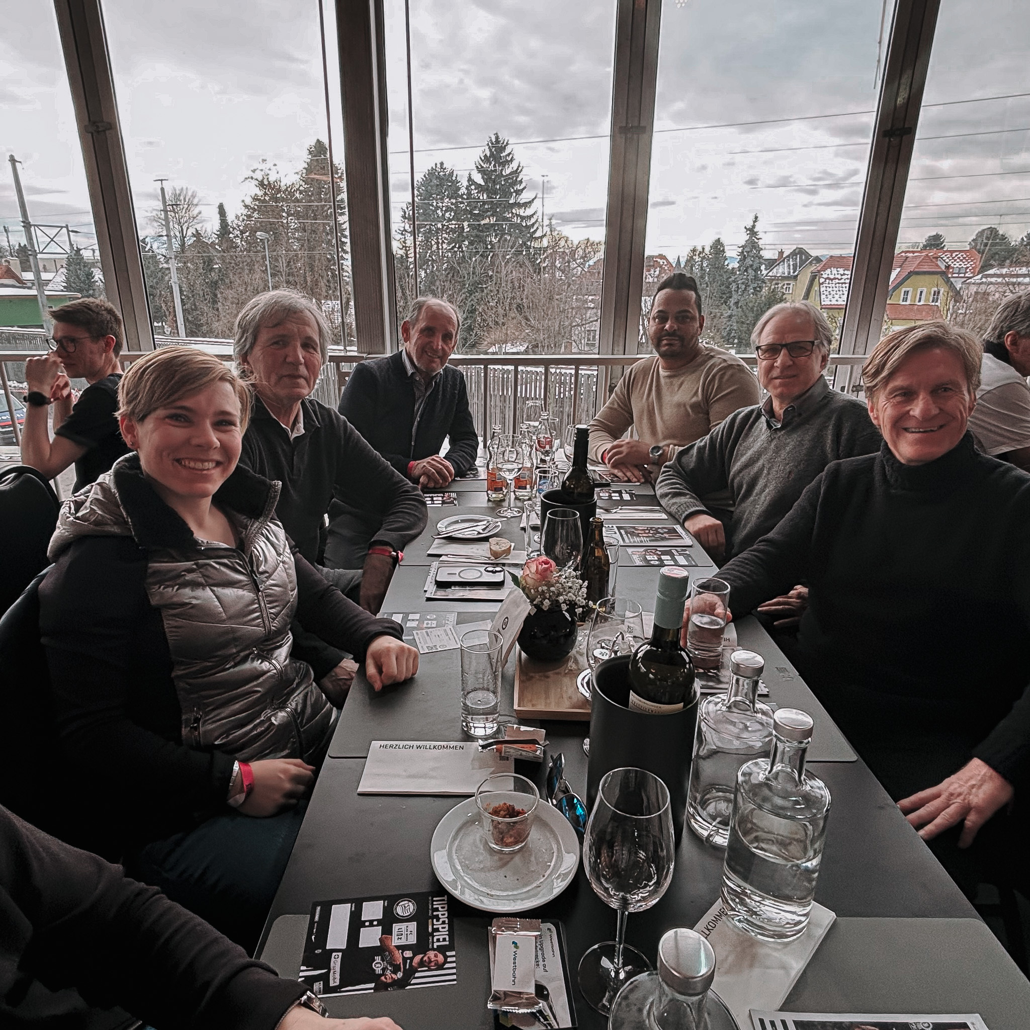 Sechs Menschen sitzen an einem Tisch.