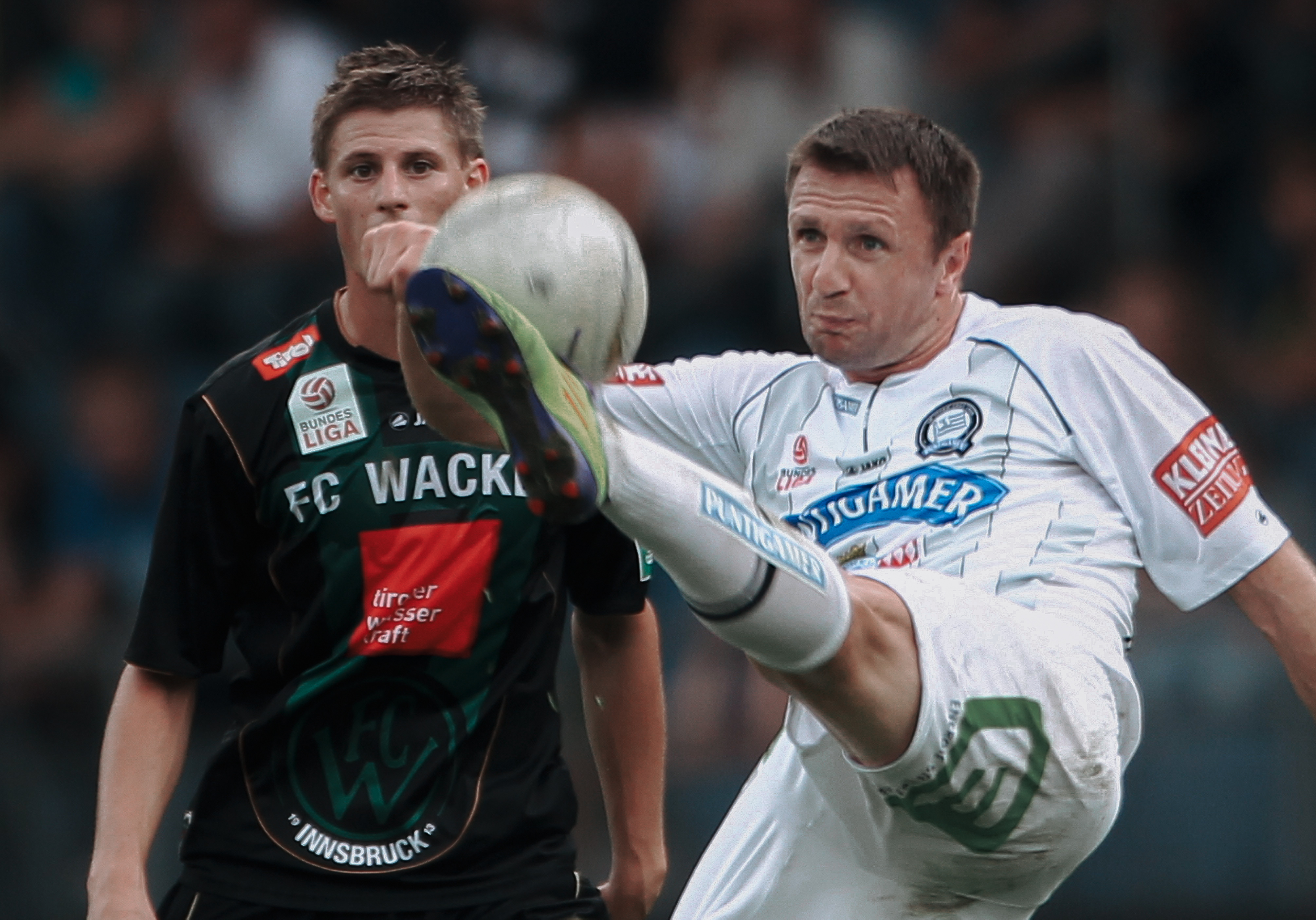 Zwei Männer spielen Fußball.