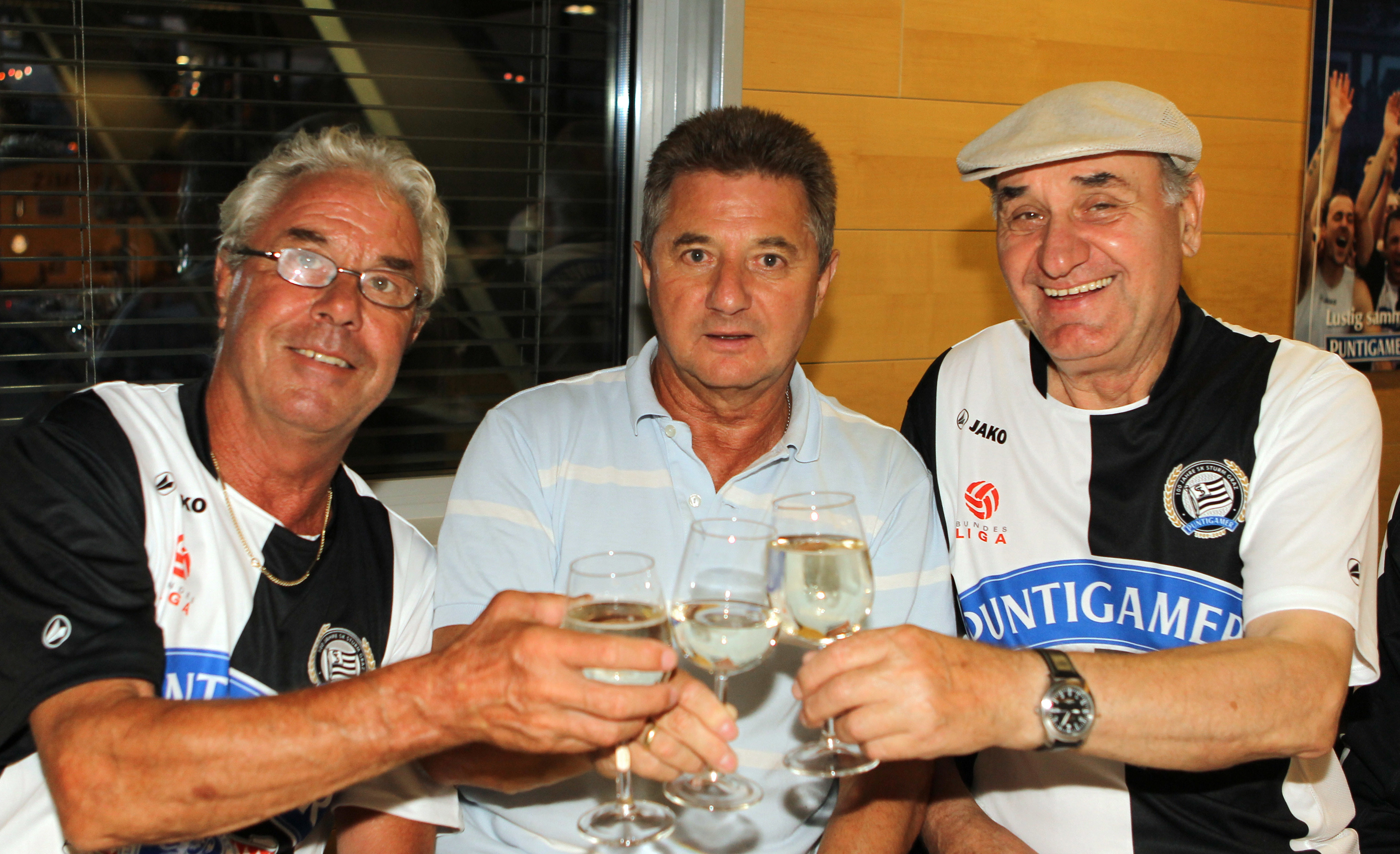 Drei Männer stoßen an.