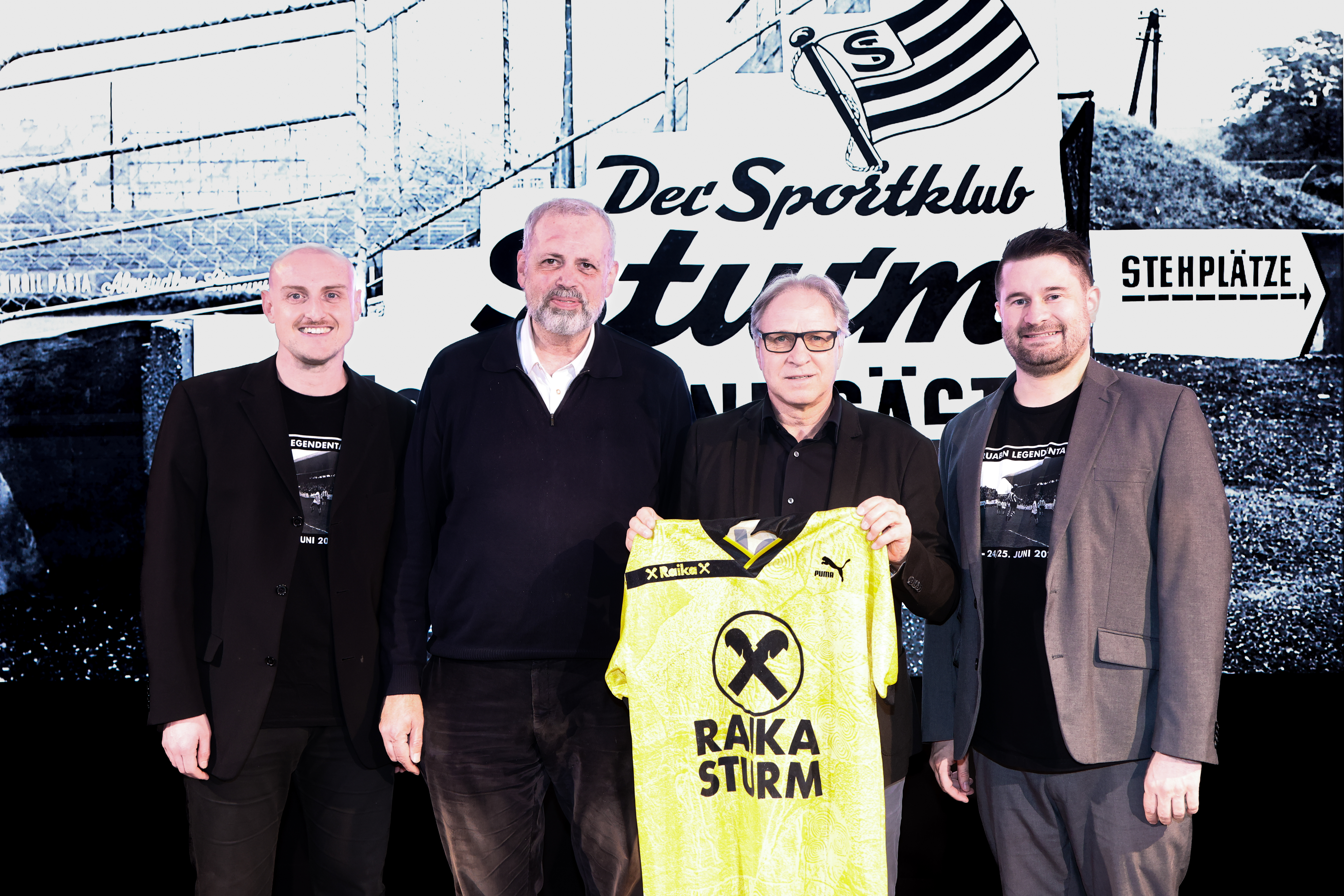 Vier Männer halten ein Trikot.