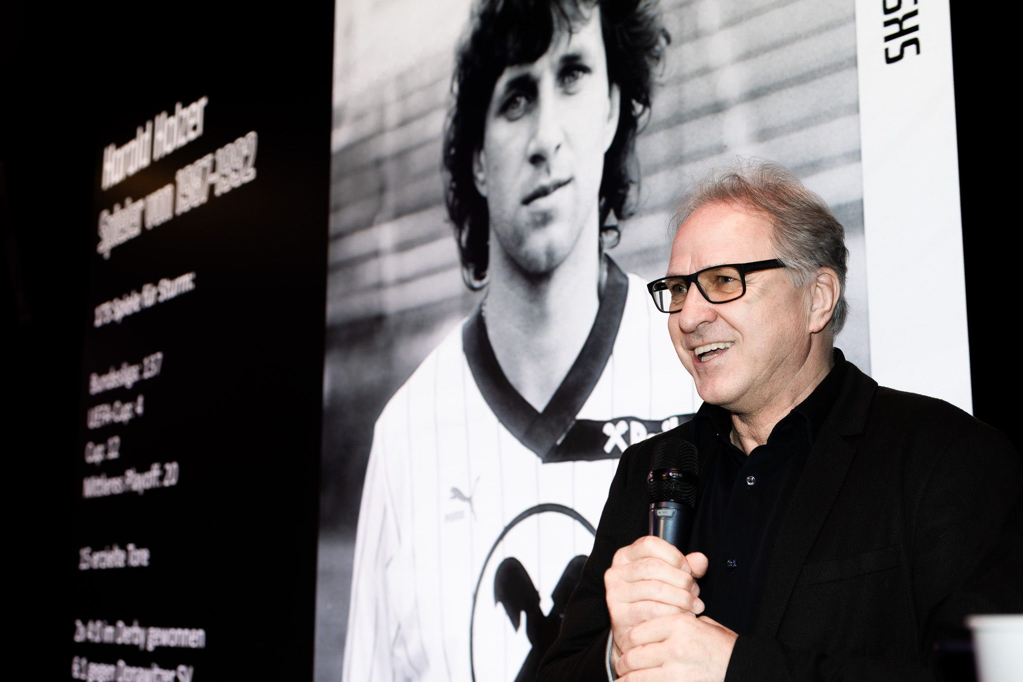 Ein Mann vor einer Leinwand.