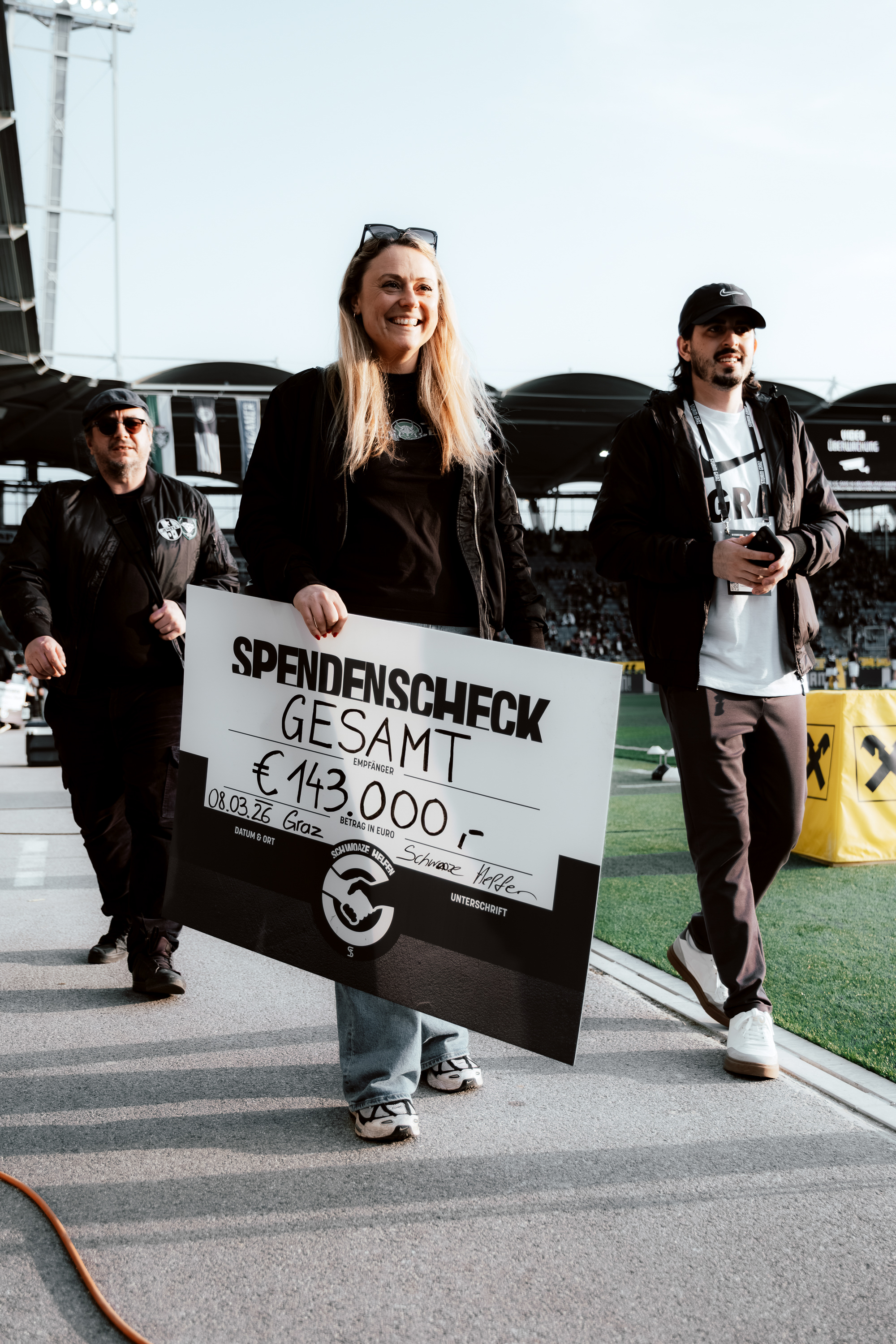 Zwei Menschen mit einem Scheck.