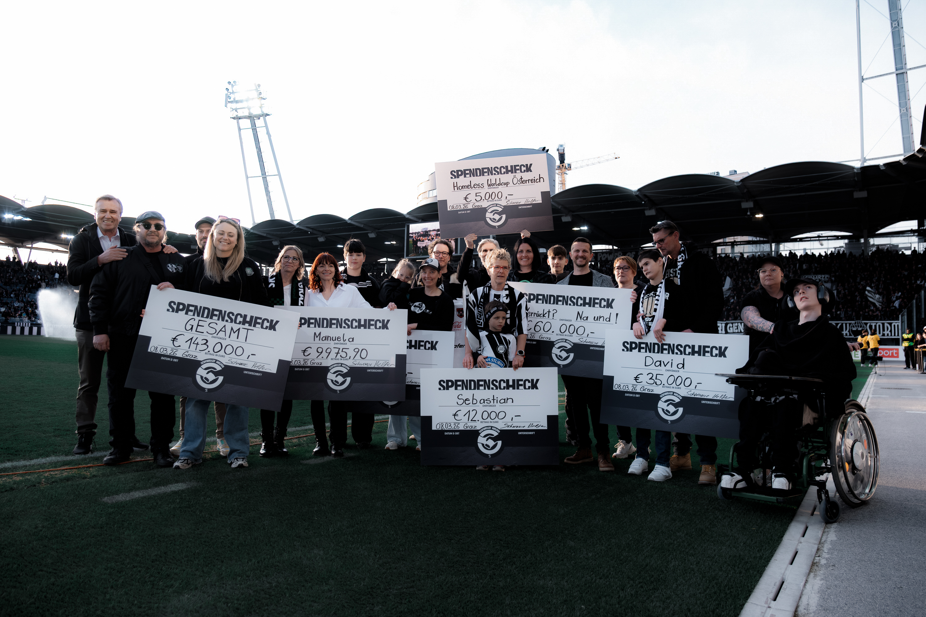 Ein Gruppenbild mit Menschen mit Schecks.