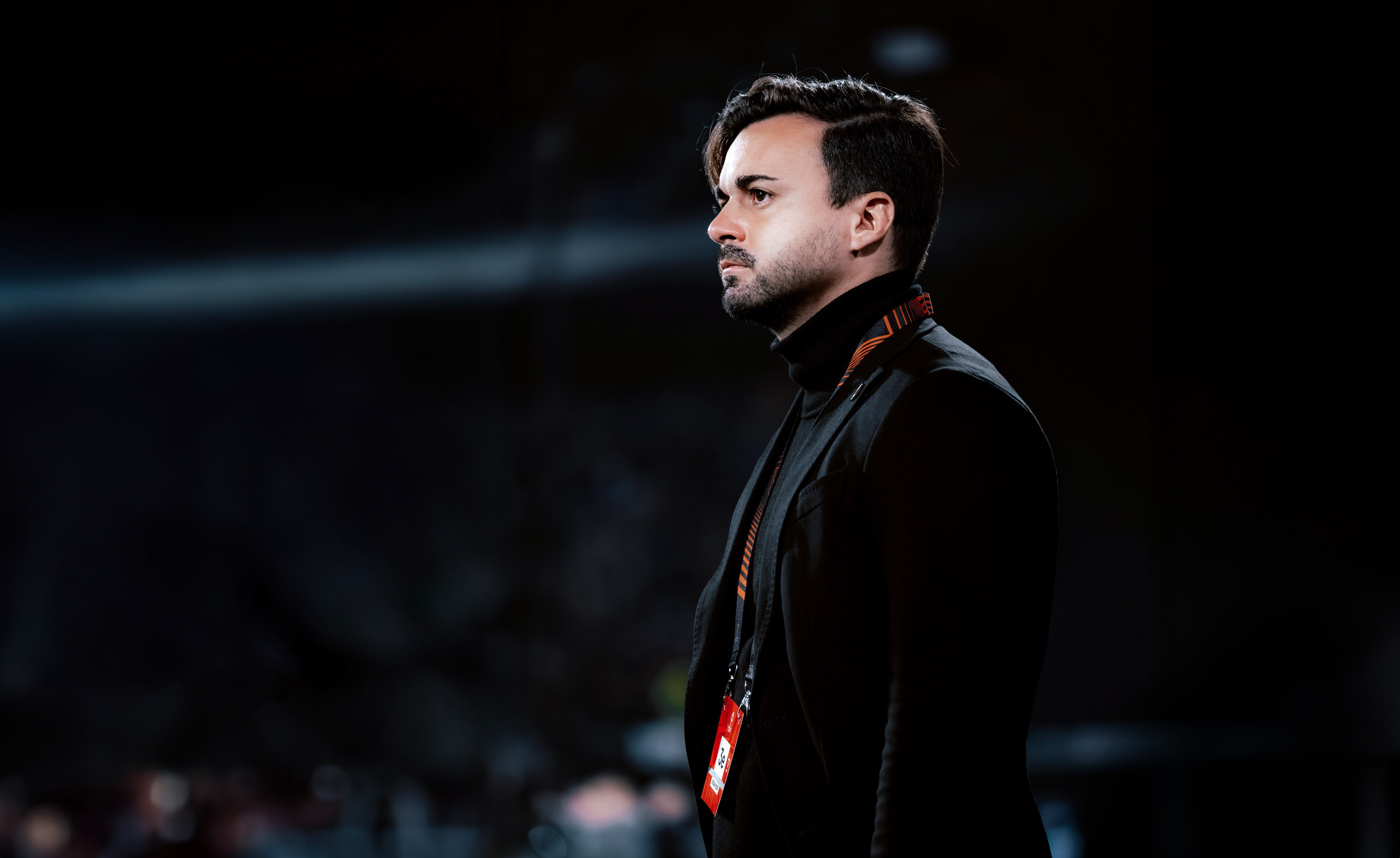 Ein Mann steht im Stadion und beobachtet das Spiel