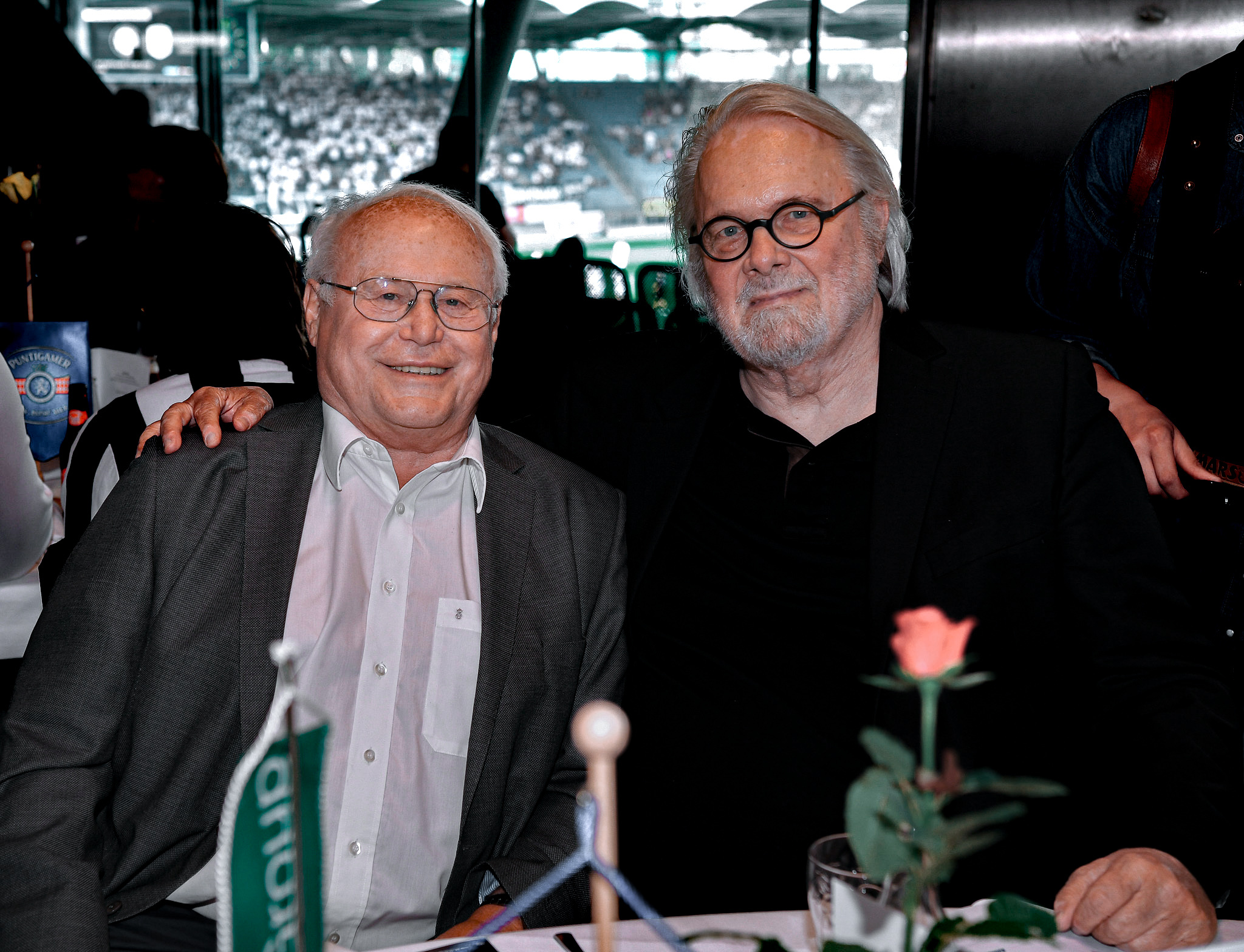 Zwei Männer sitzen, umarmen sich