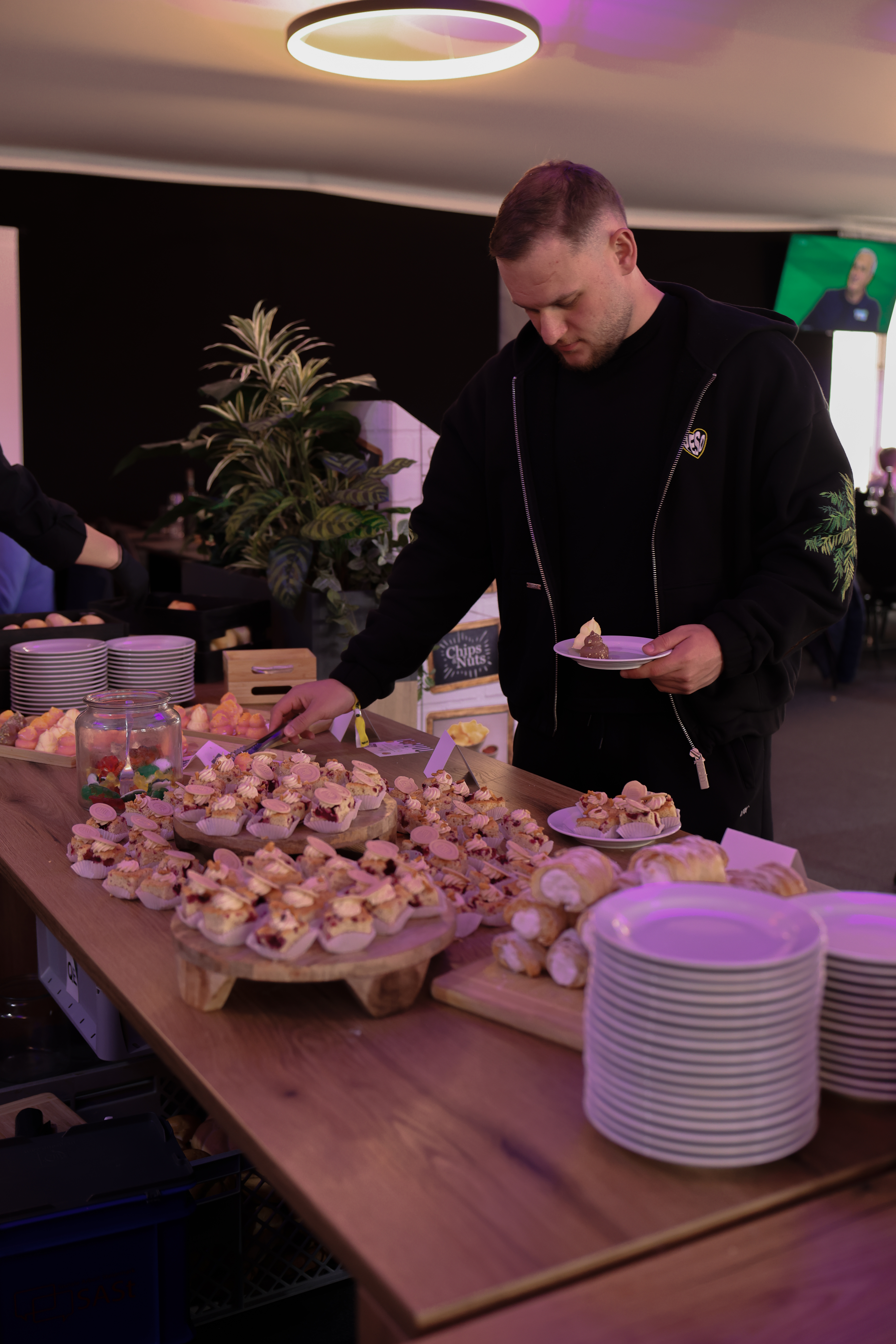 Ein Mann, der sich ein Törtchen vom Buffet nimmt.