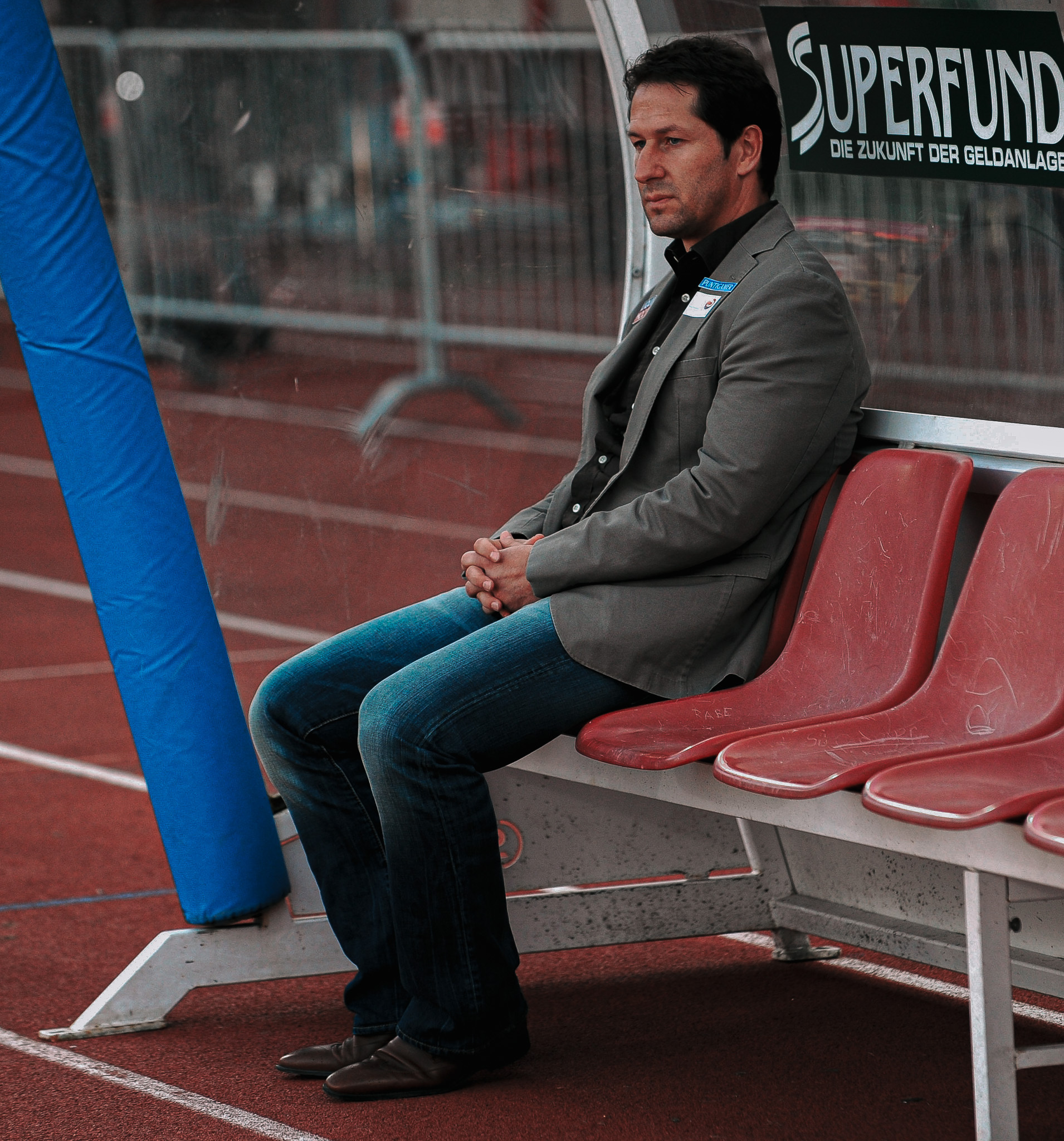 Ein Mann sitzt auf einer Trainerbank