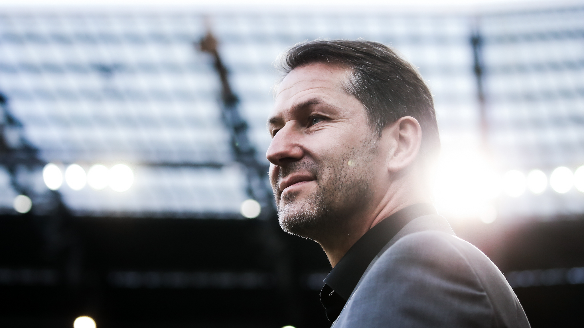 Ein Mann schaut in einem Stadion in die Ferne