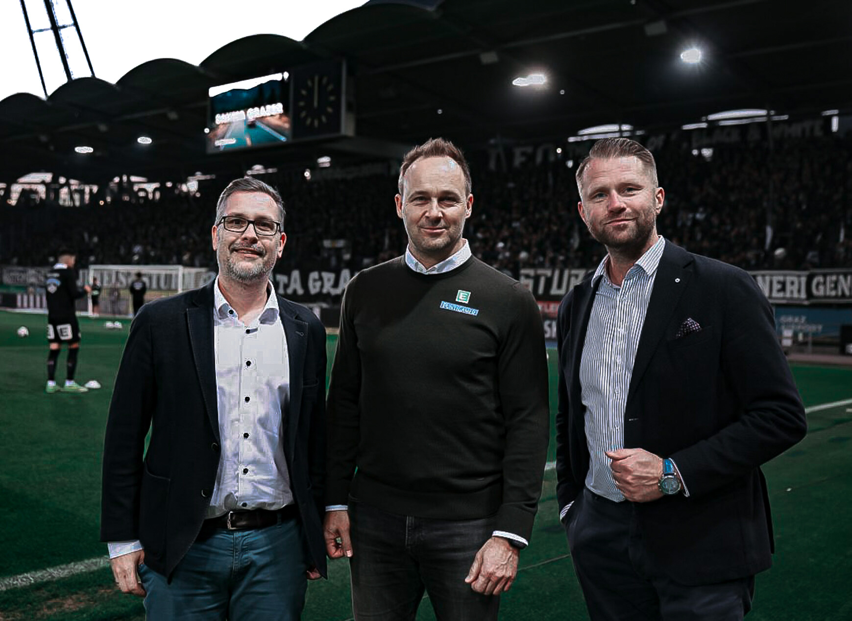 Drei Männer in einem Fußballstadion