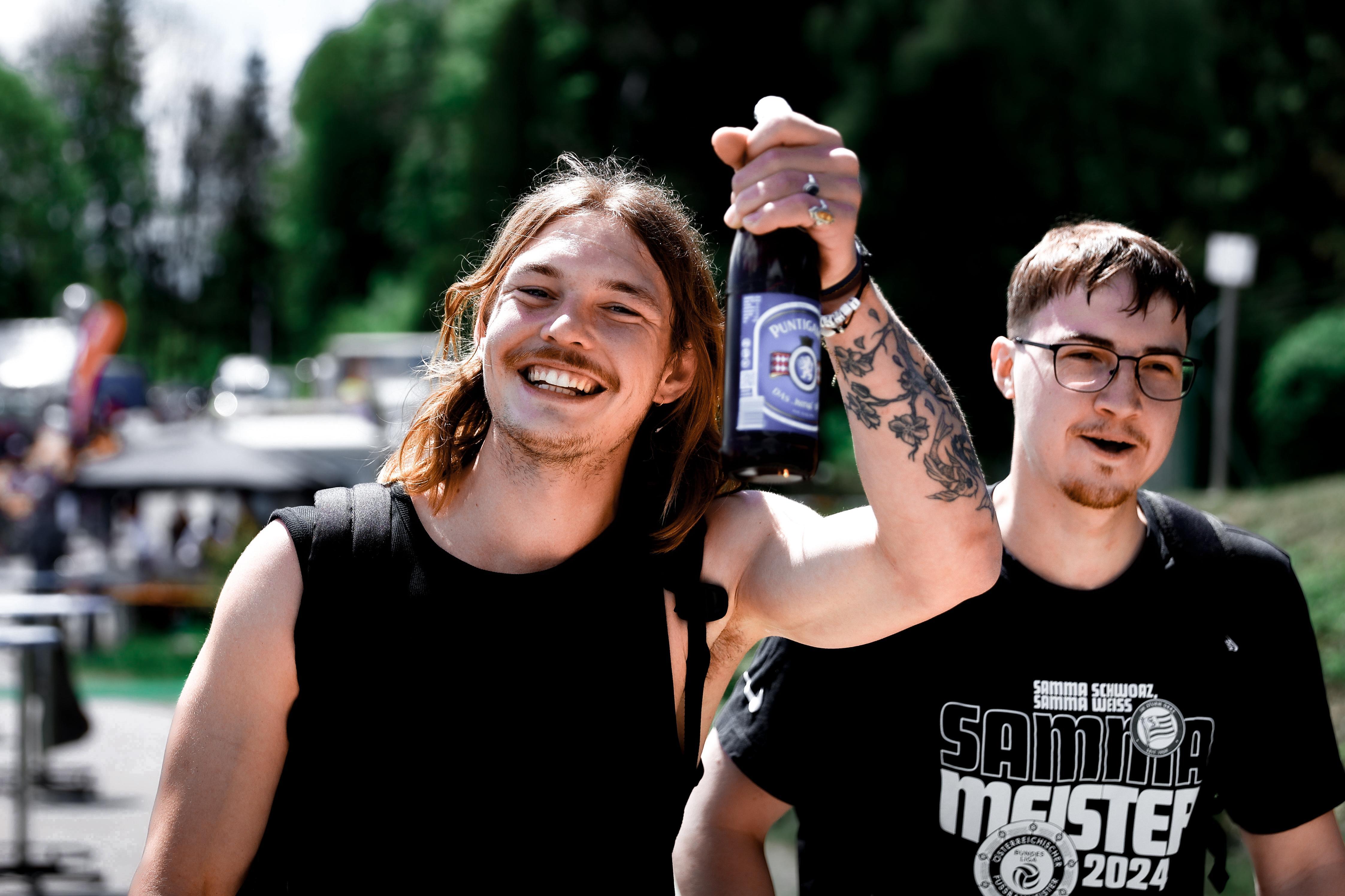 Zwei Personen mit einer Flasche Bier.
