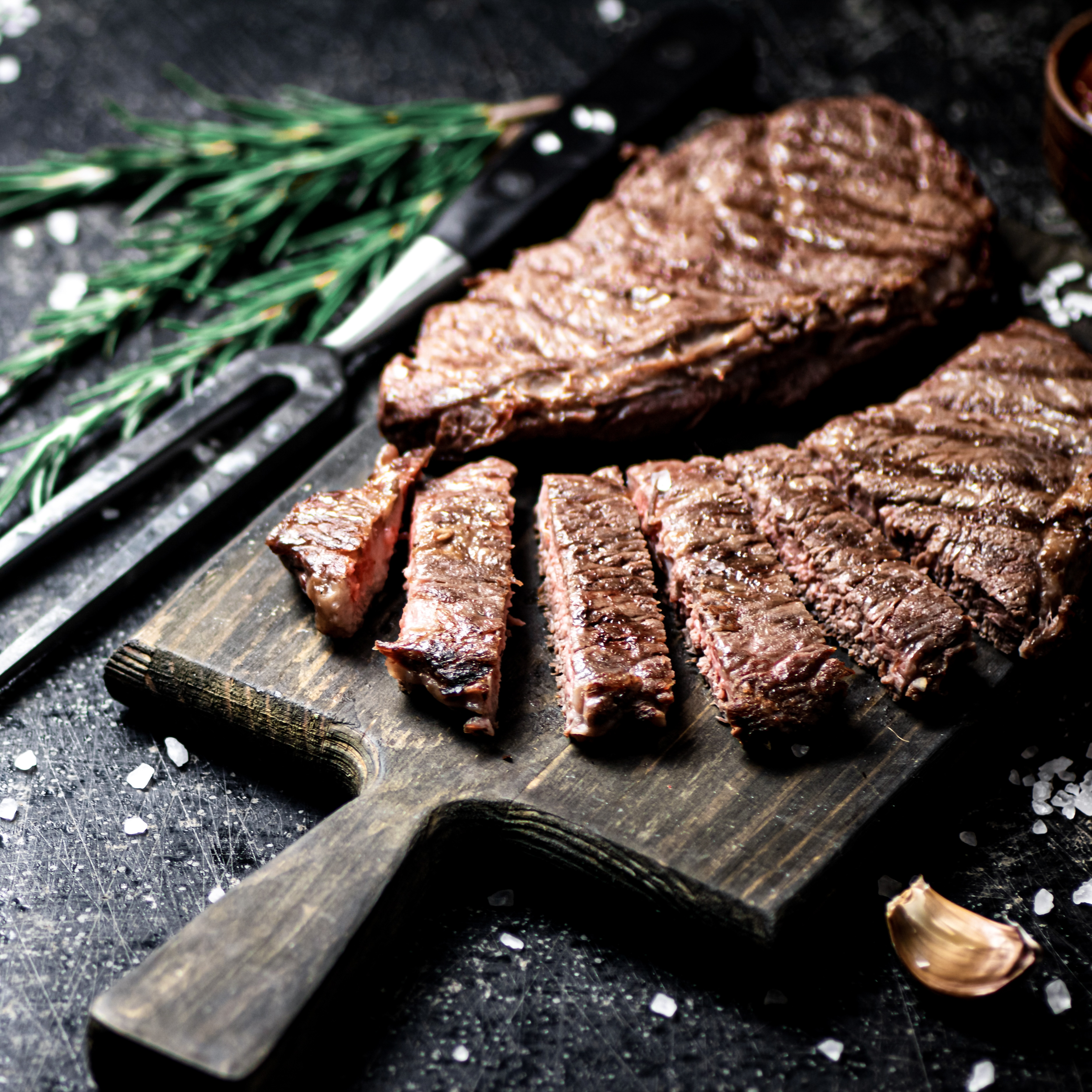 Ein gegrilltes Steak geschnitten auf einer schwarzen Platte