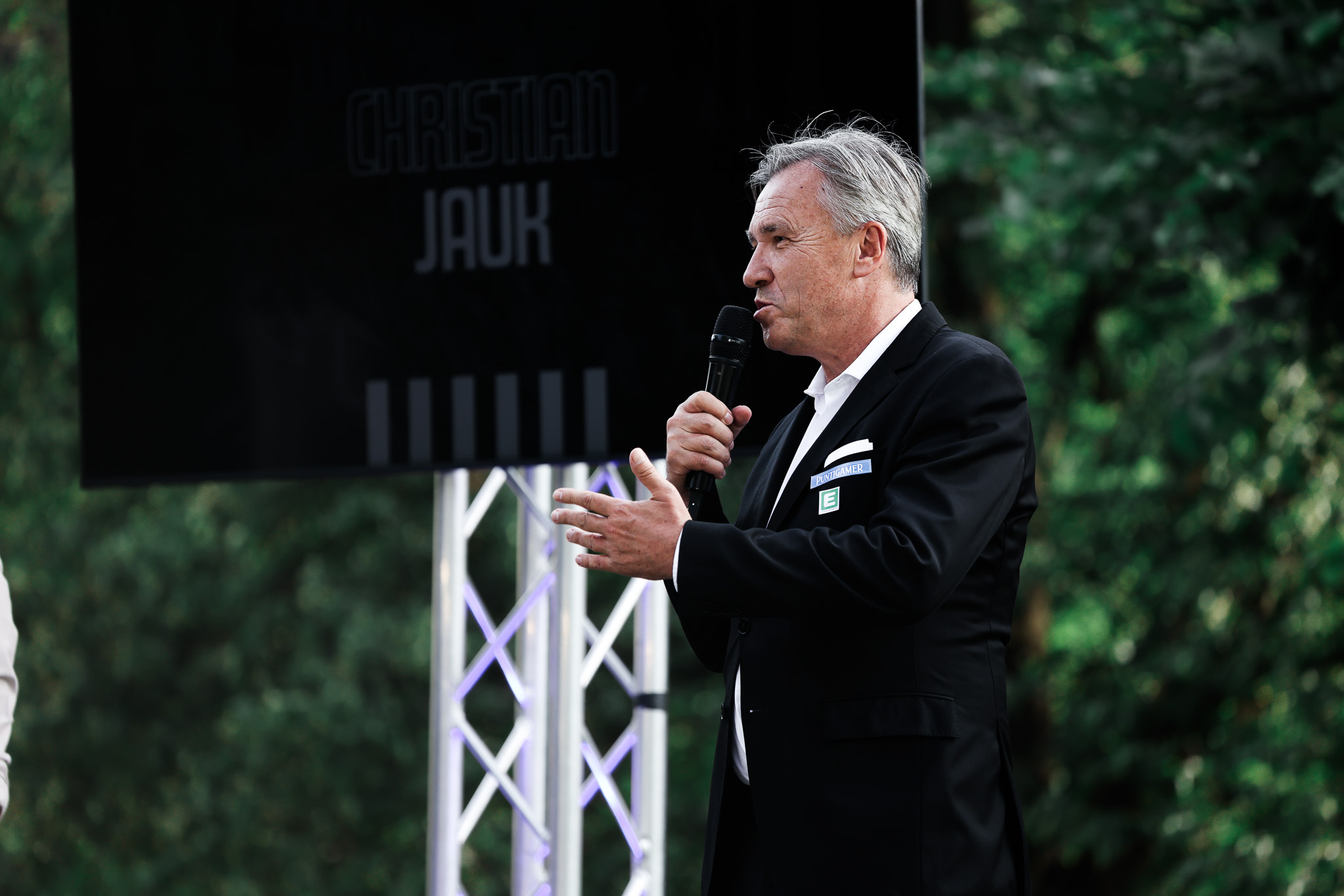 Ein Mann im Anzug spricht in ein Mikrofon