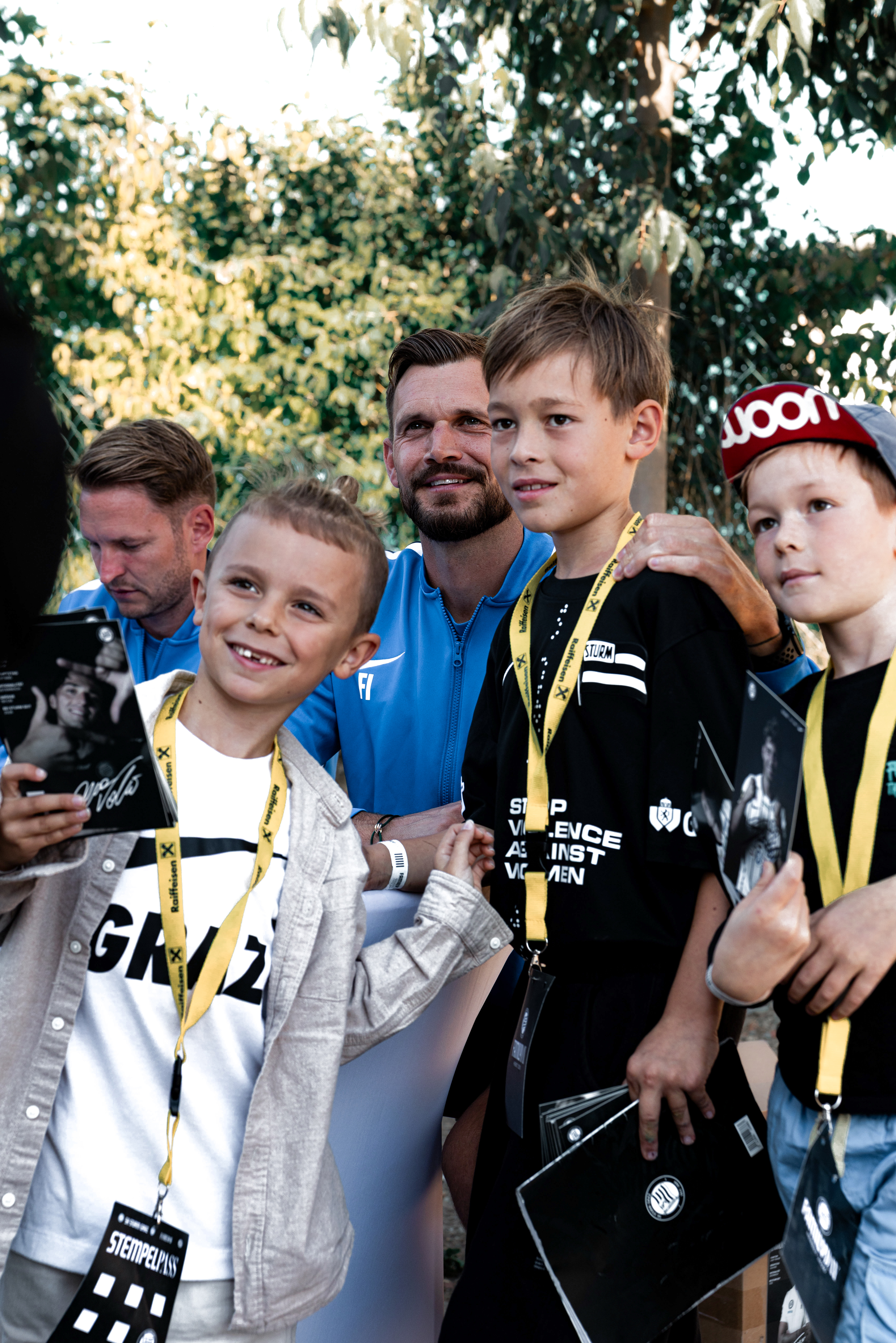 Ein Mann posiert mit vier Fans.
