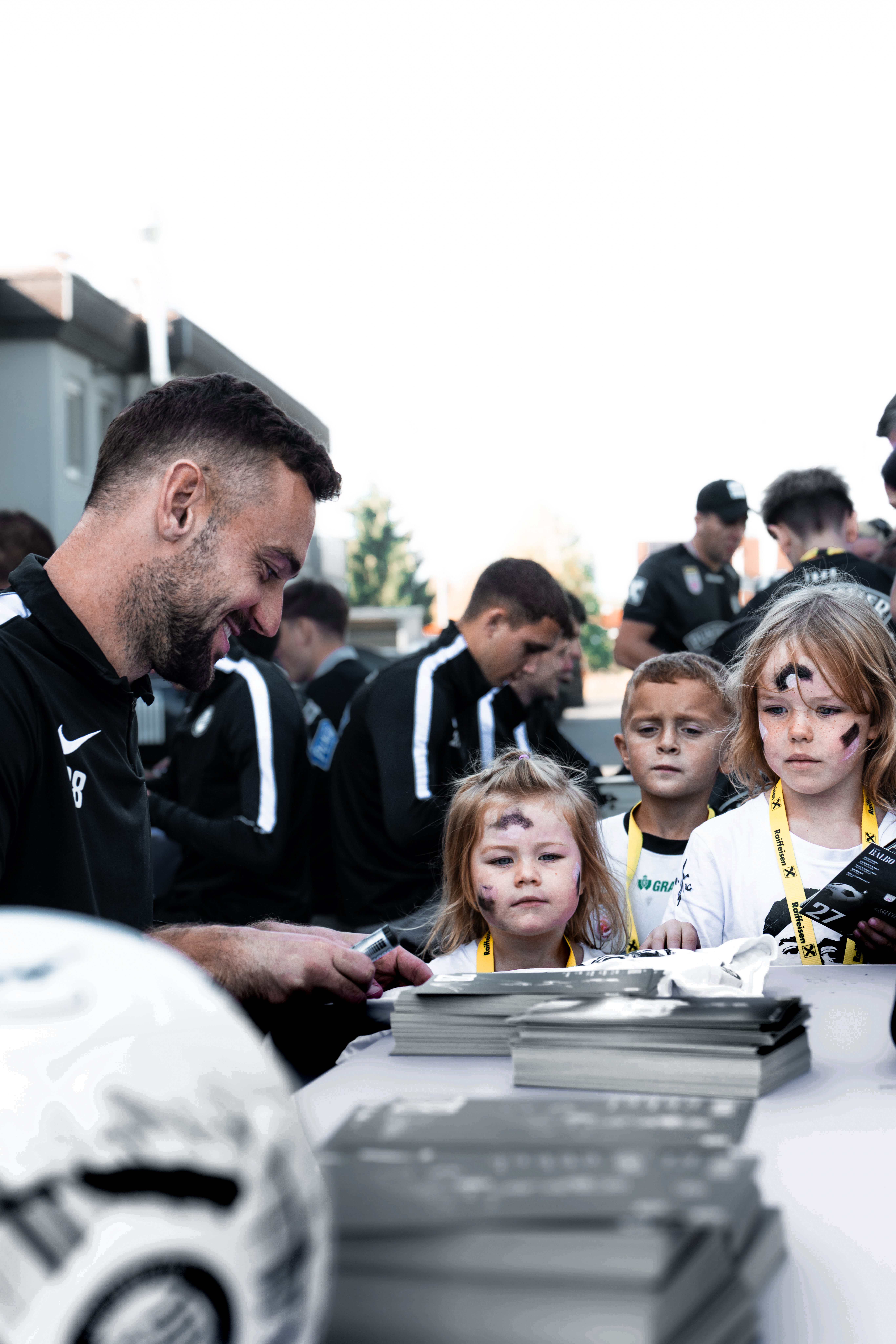 Ein Spieler unterschreibt eine Autogrammkarte.