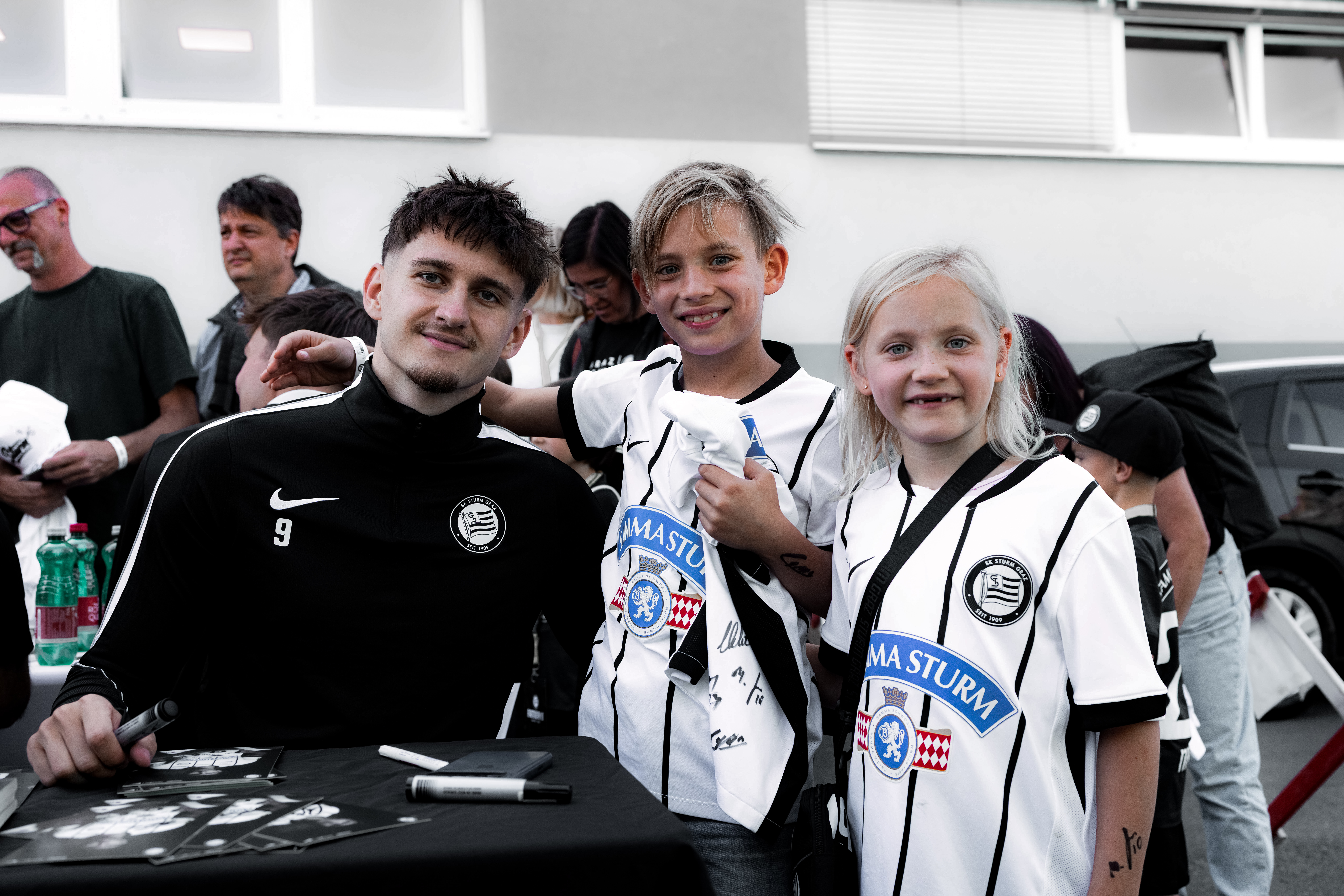Ein Spieler mit zwei Kinder im Trikot.