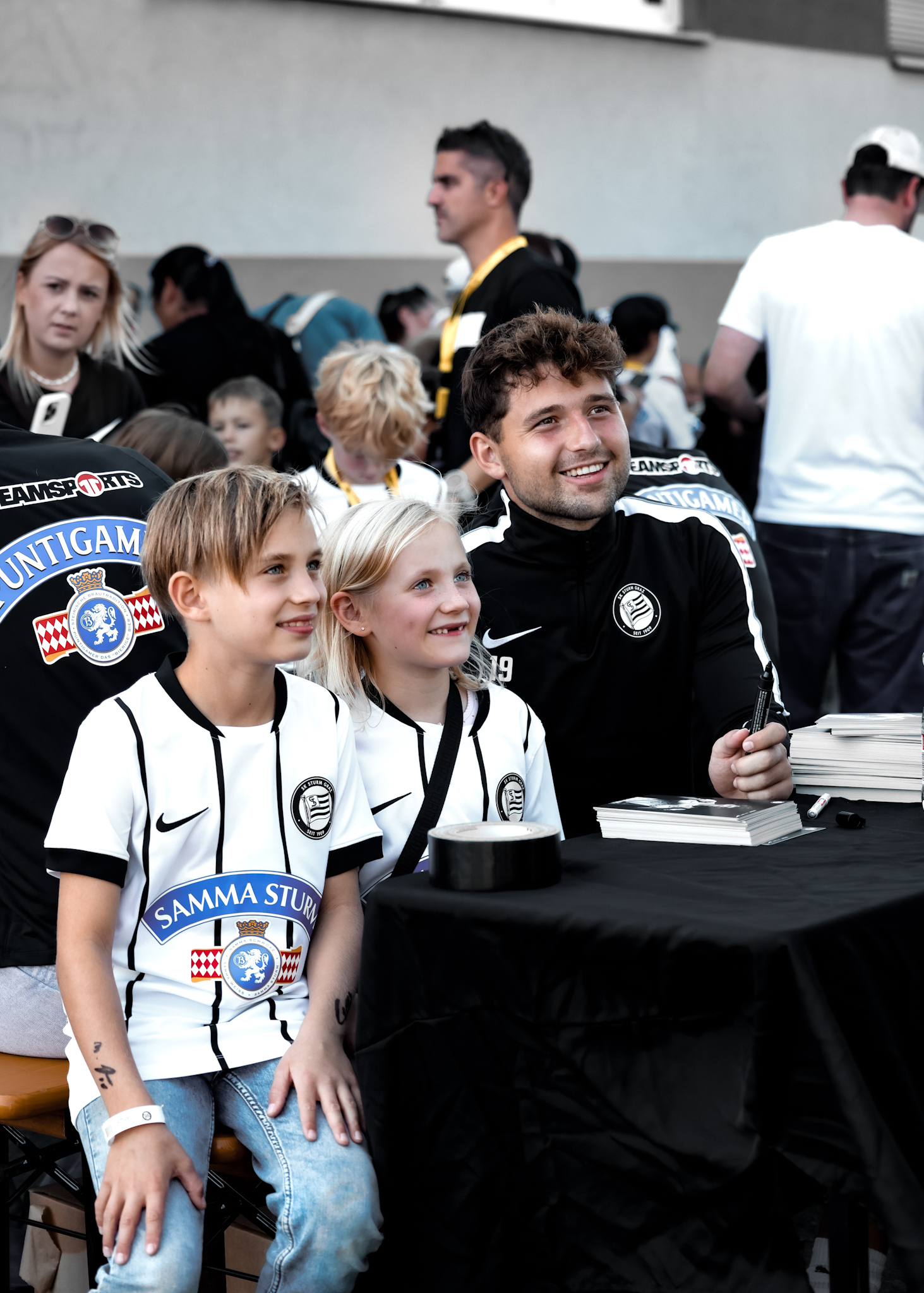 Ein Spieler posiert mit zwei Kindern.