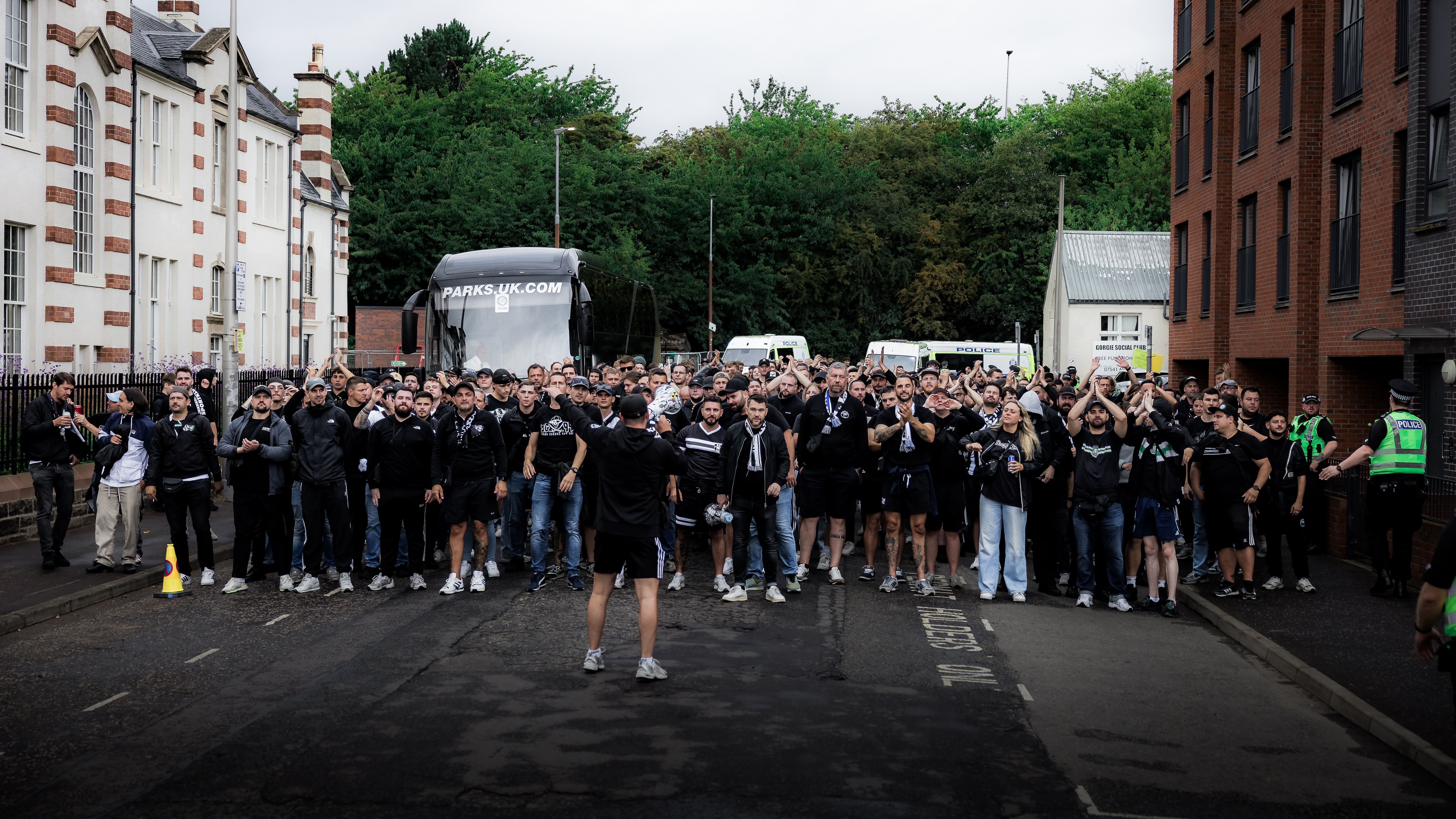 Viele Menschen in schwarz stehen in einer Straße