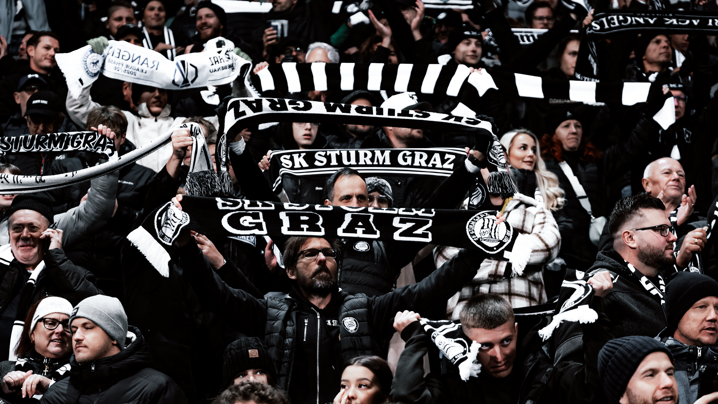 viele Fans mit schwarzen und weißen Schals