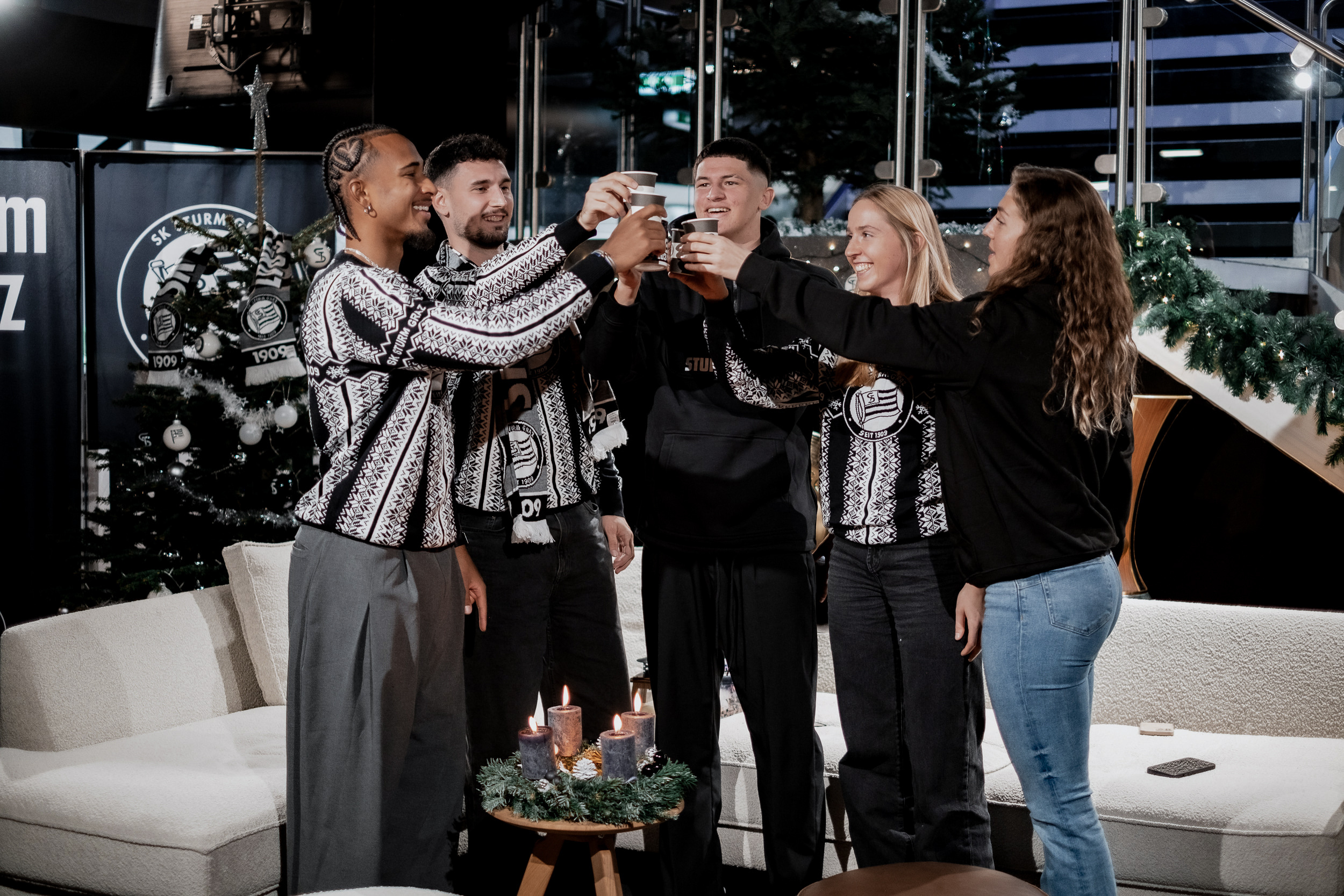 Eine Gruppe stoßt auf Weihnachten mit Becher an