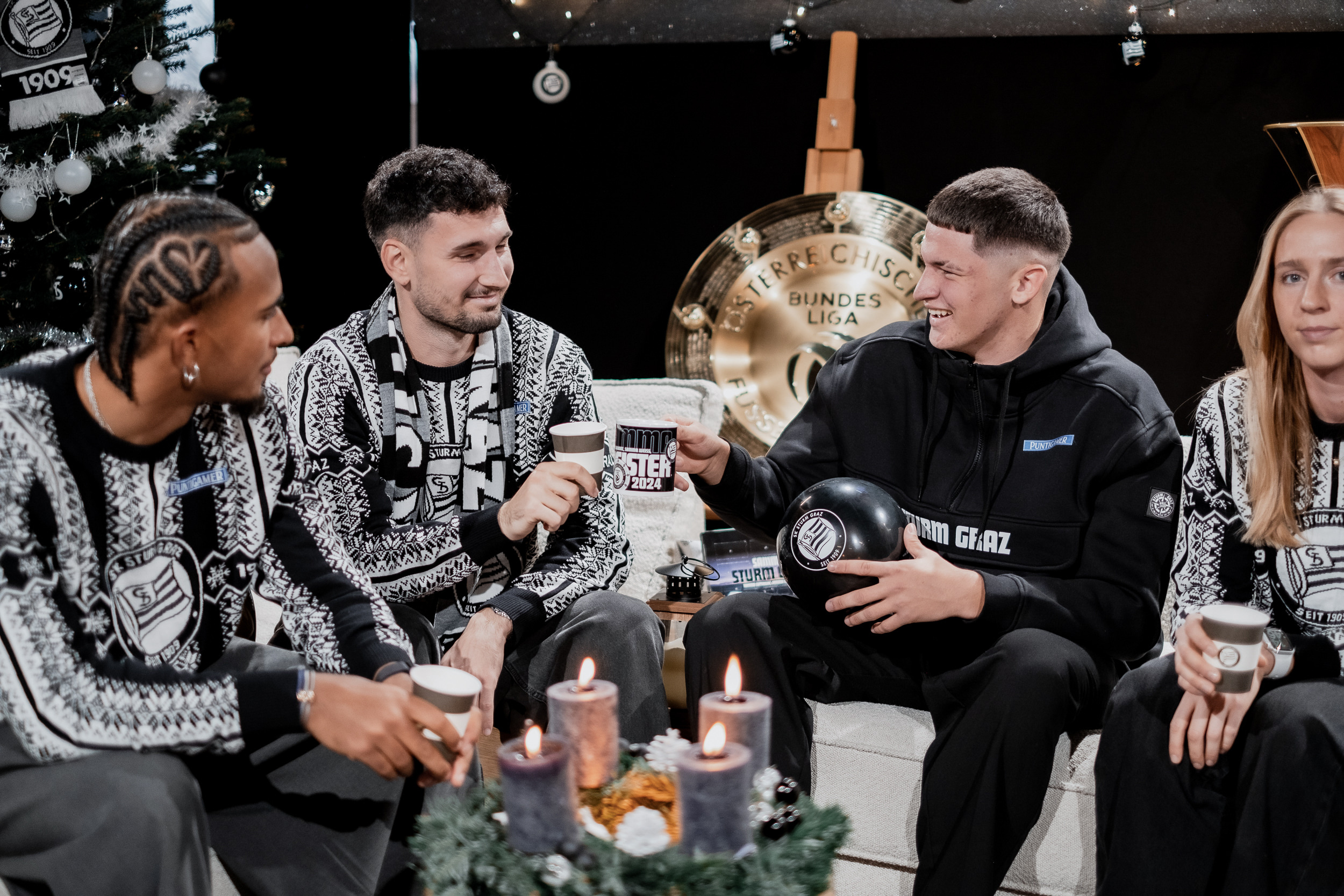 Vier Personen im weihnachtlichem Outfit feiern Weihnachten