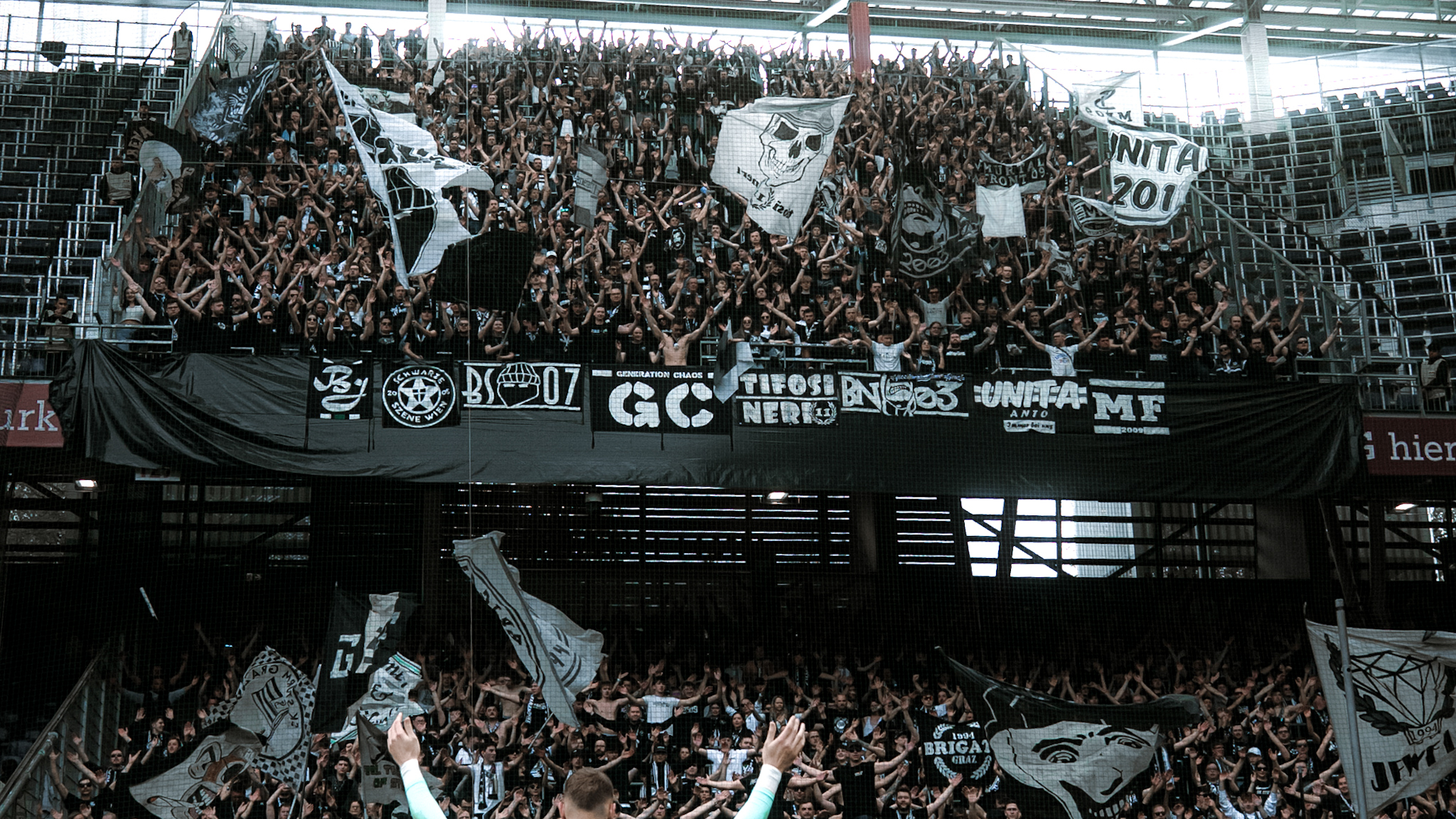 Tausend Menschen halten ihre Arme in die Höhe