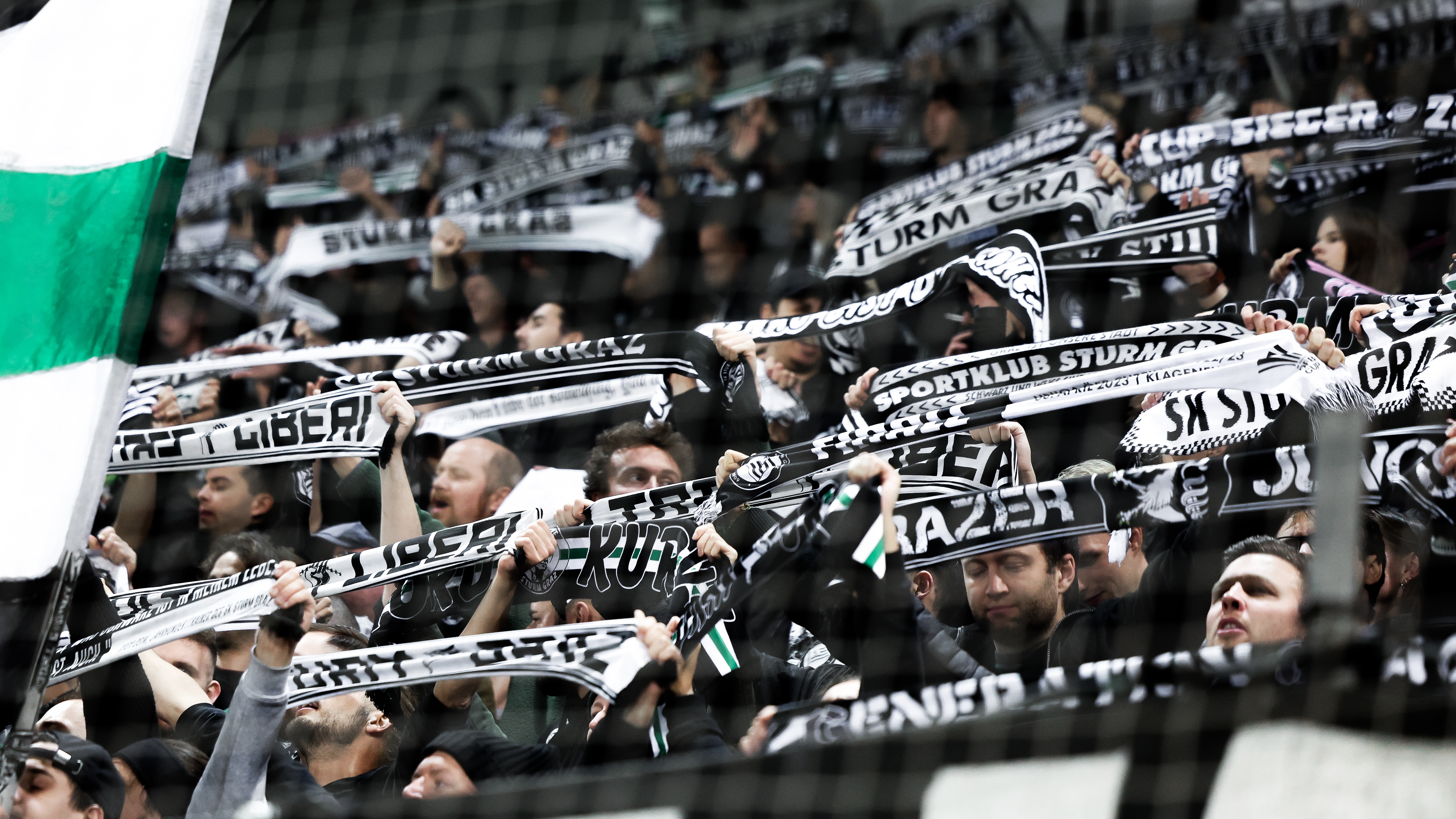 Viele Fans halten schwarz-weiße Schals in die Höhe