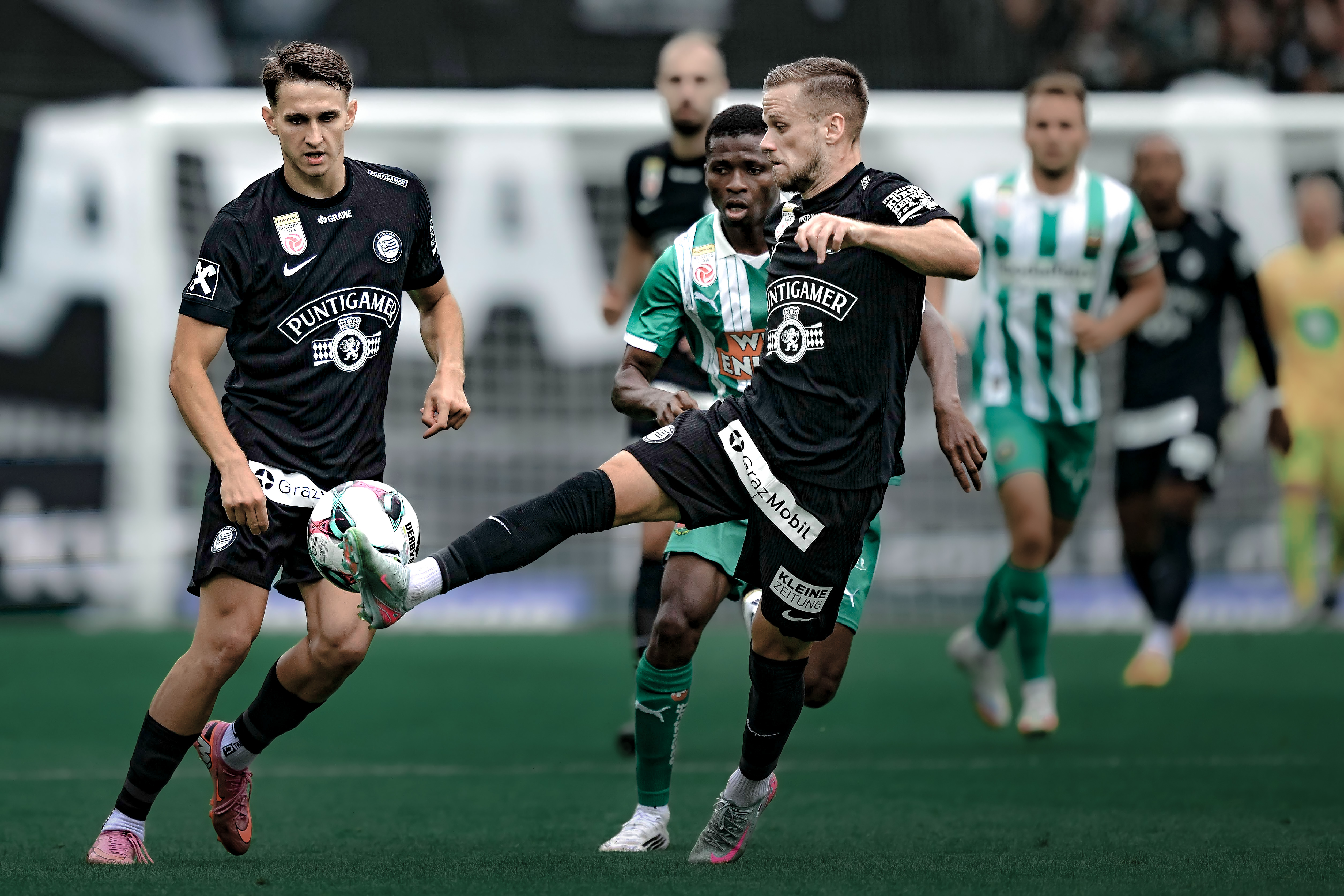Drei Spieler im Kampf um den Ball