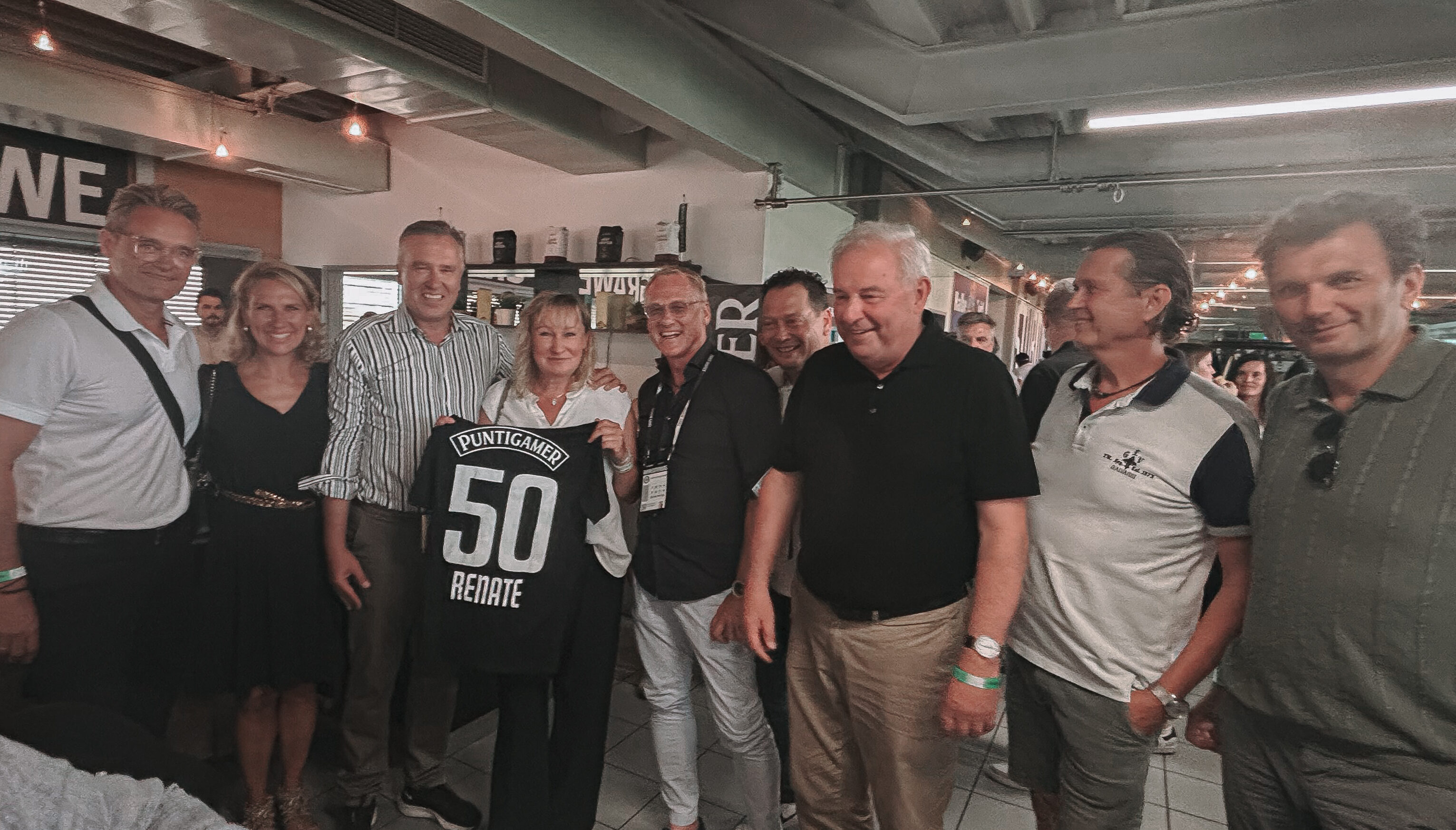 Eine Gruppe mit einer Frau mit einem Trikot im Mittelpunkt.