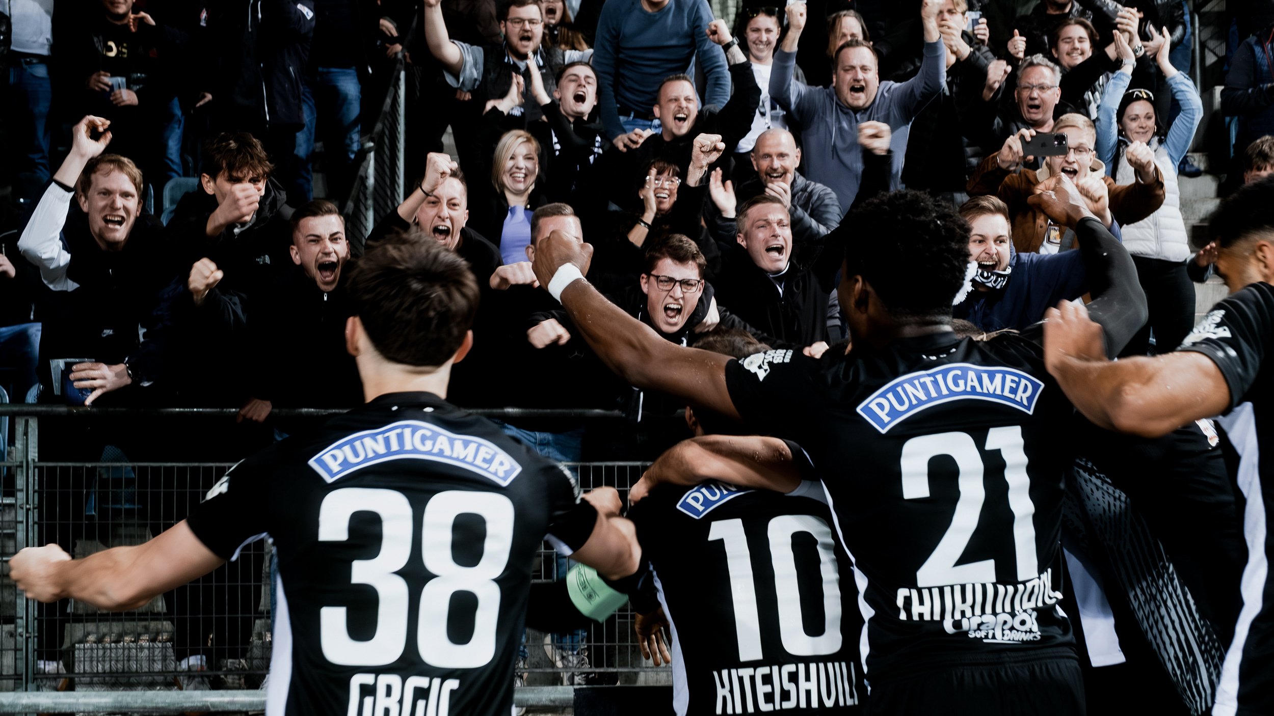 Vier Spieler, die vor Fans jubeln