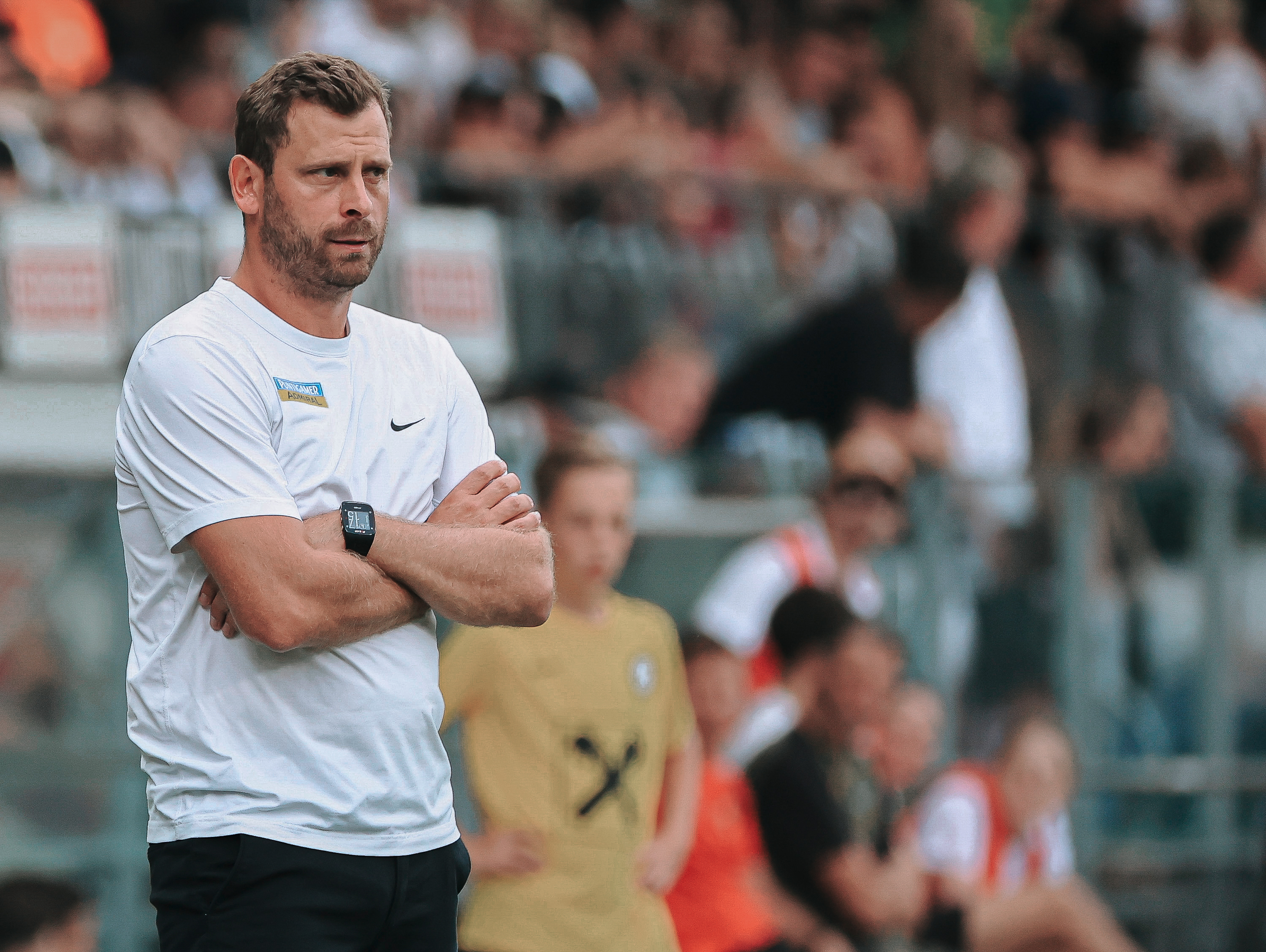 Ein Mann mit verschränkten Armen im Stadion.