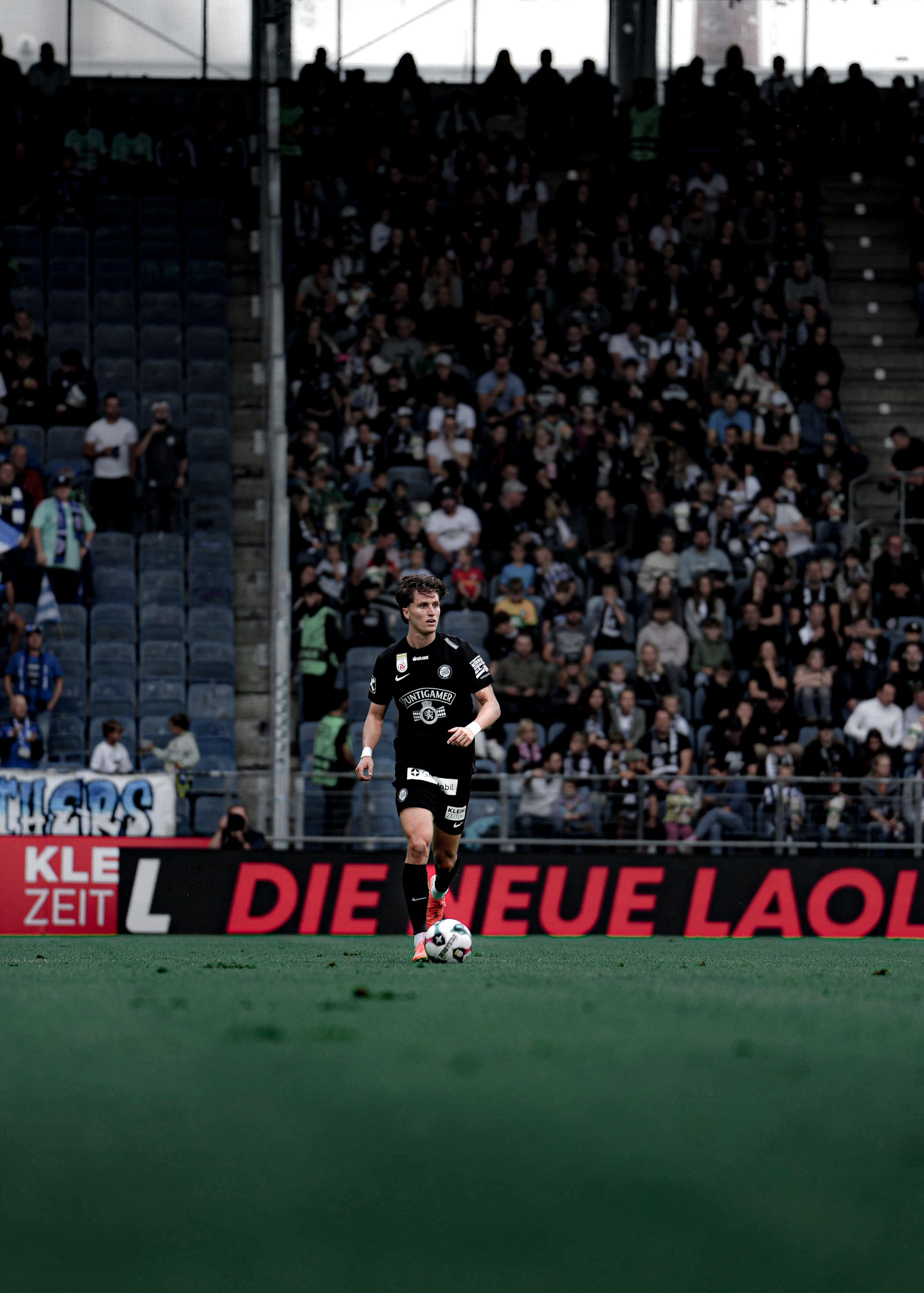 En Mann mit Ball am Fuß.